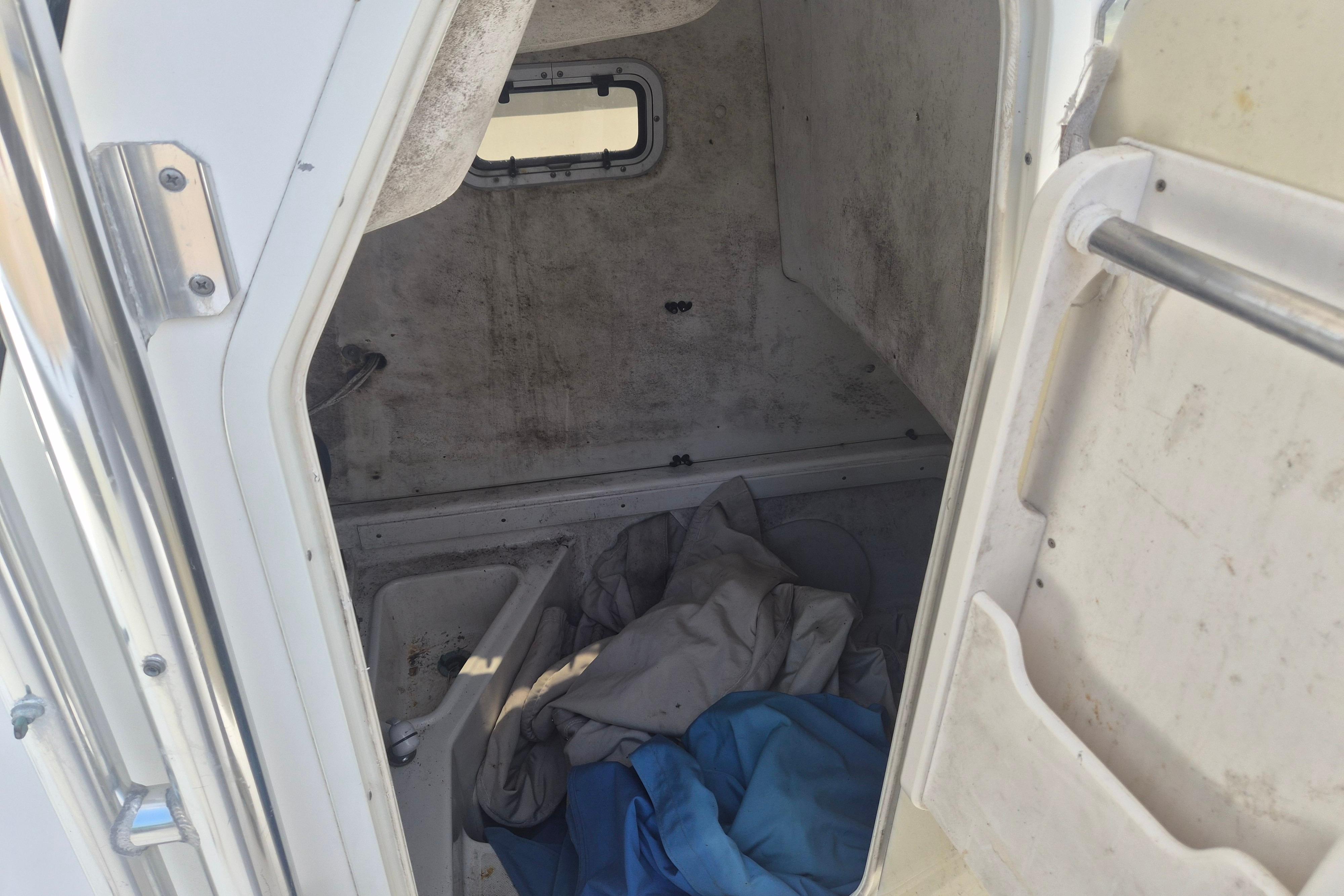 Interior cabin of a 2006 Century 2900 Center Console boat with stored items.