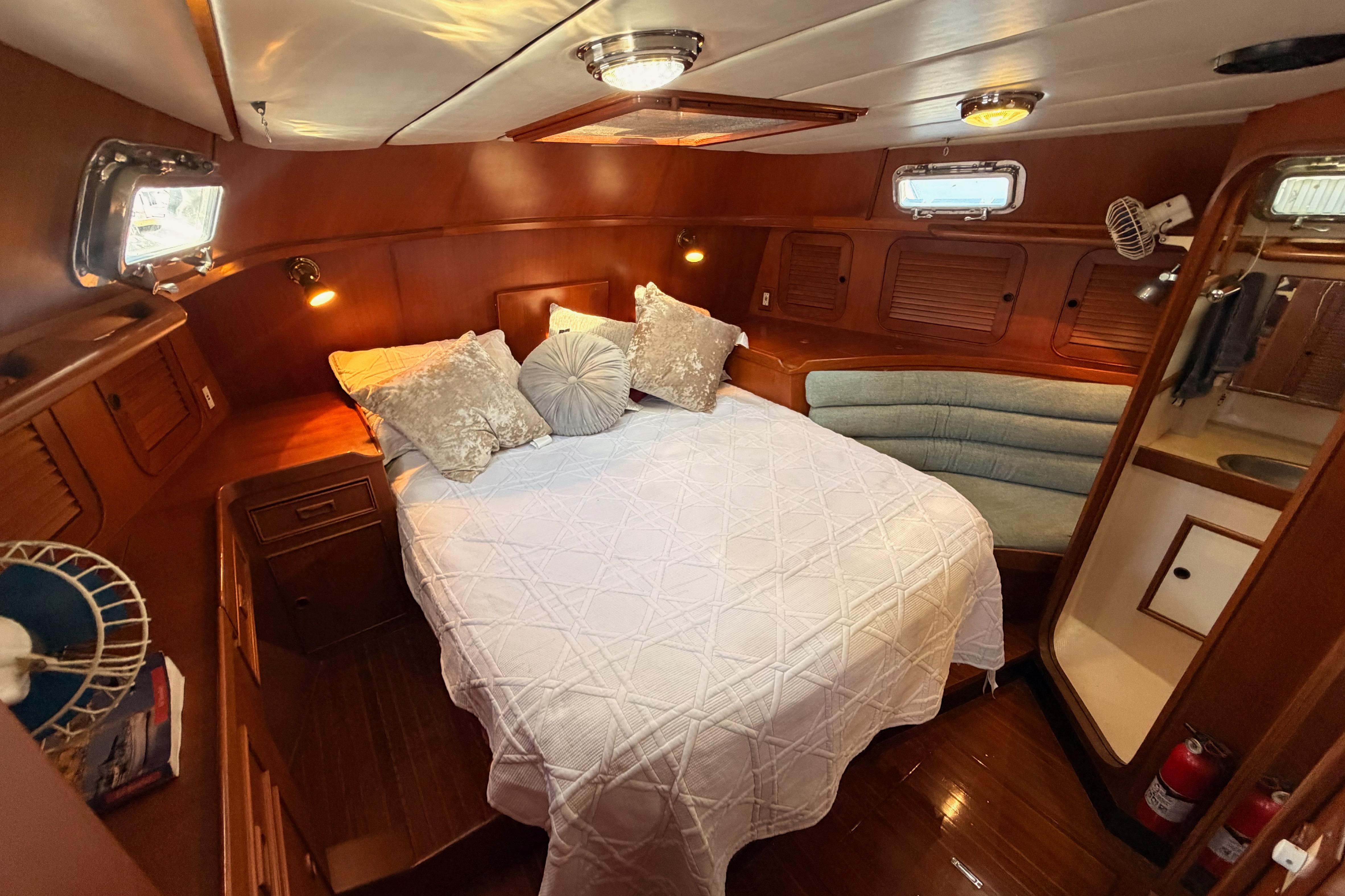 Luxurious 1991 Hylas 51 yacht cabin with cozy bed and elegant wood finish.