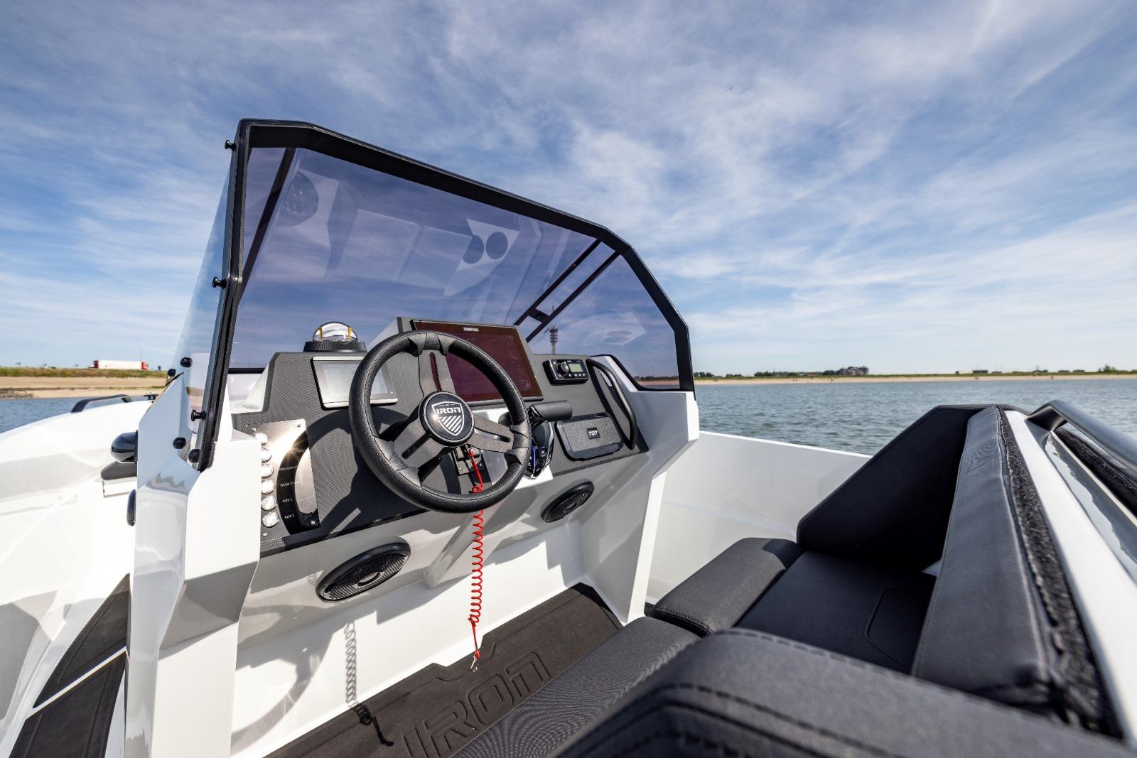 Interior view of 2022 Iron 707 boat cockpit with steering wheel and dashboard.
