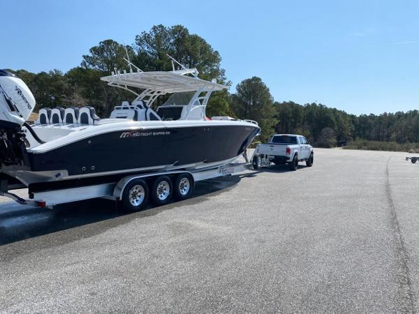 2019 Midnight Express 39 Cuddy boat on trailer, towed by a truck in a parking area.