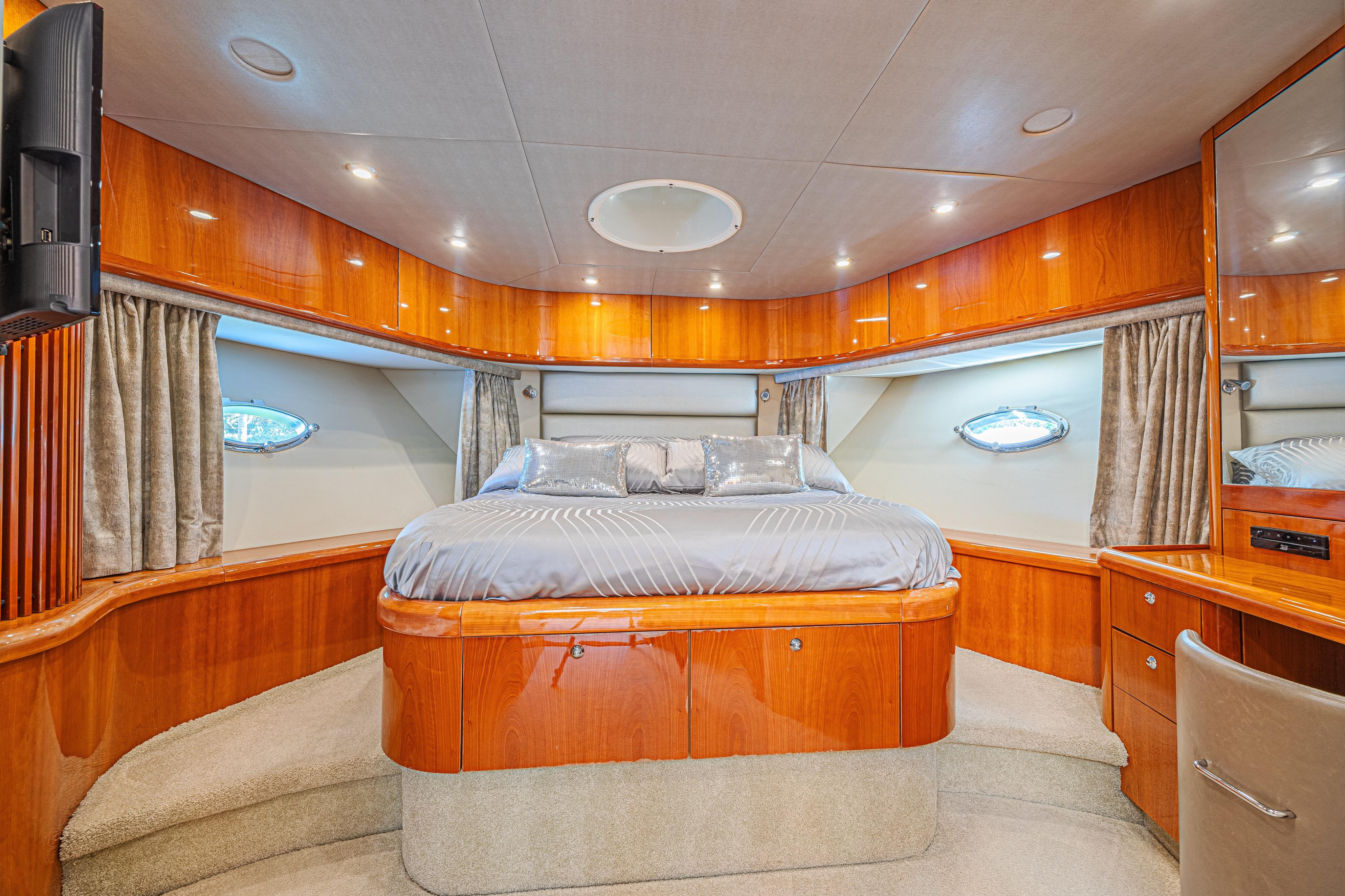 Luxurious bedroom interior of 2006 Sunseeker 75 Yacht with elegant wood finish.