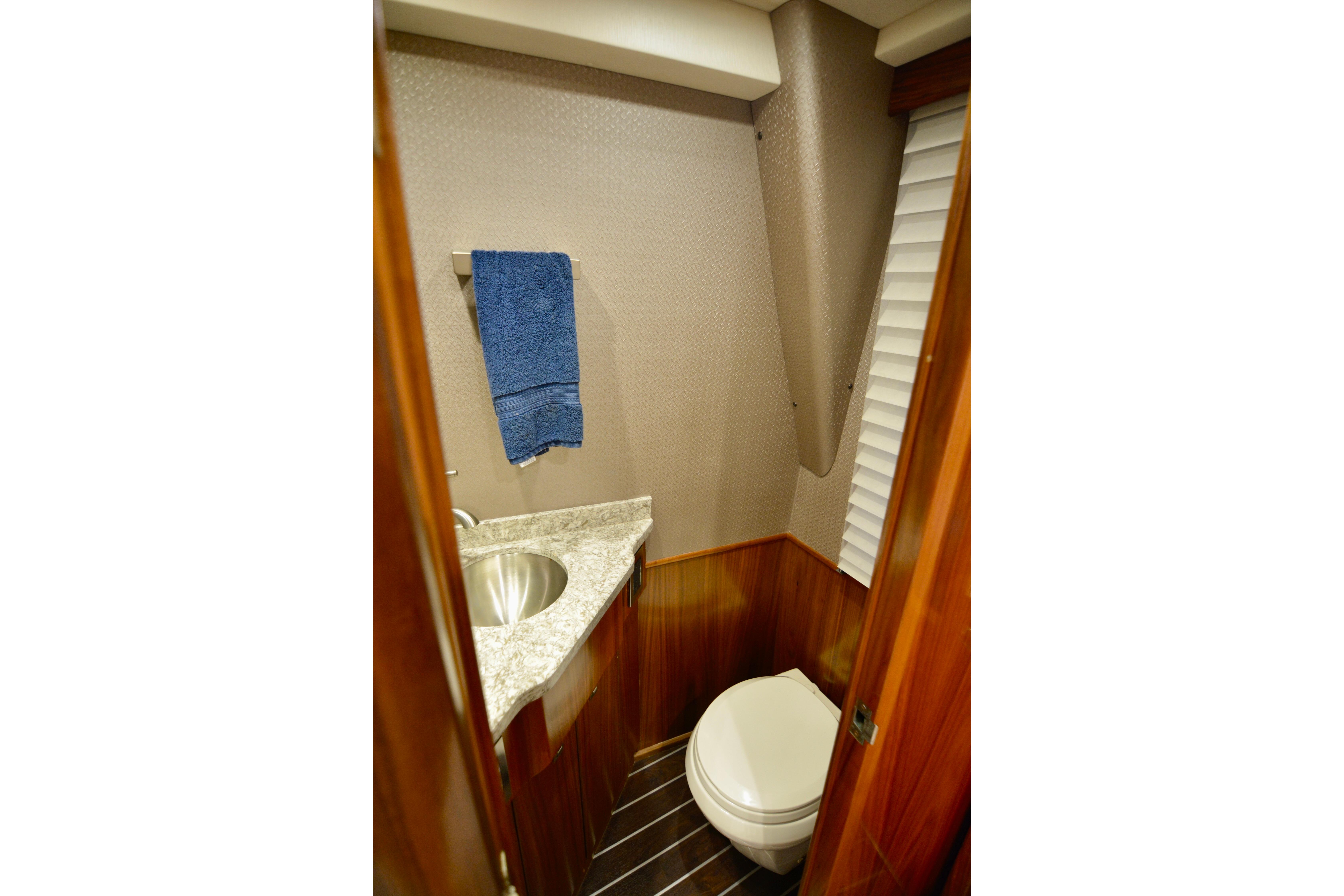 2019 Viking 68 Convertible yacht bathroom with marble countertop and wooden accents.