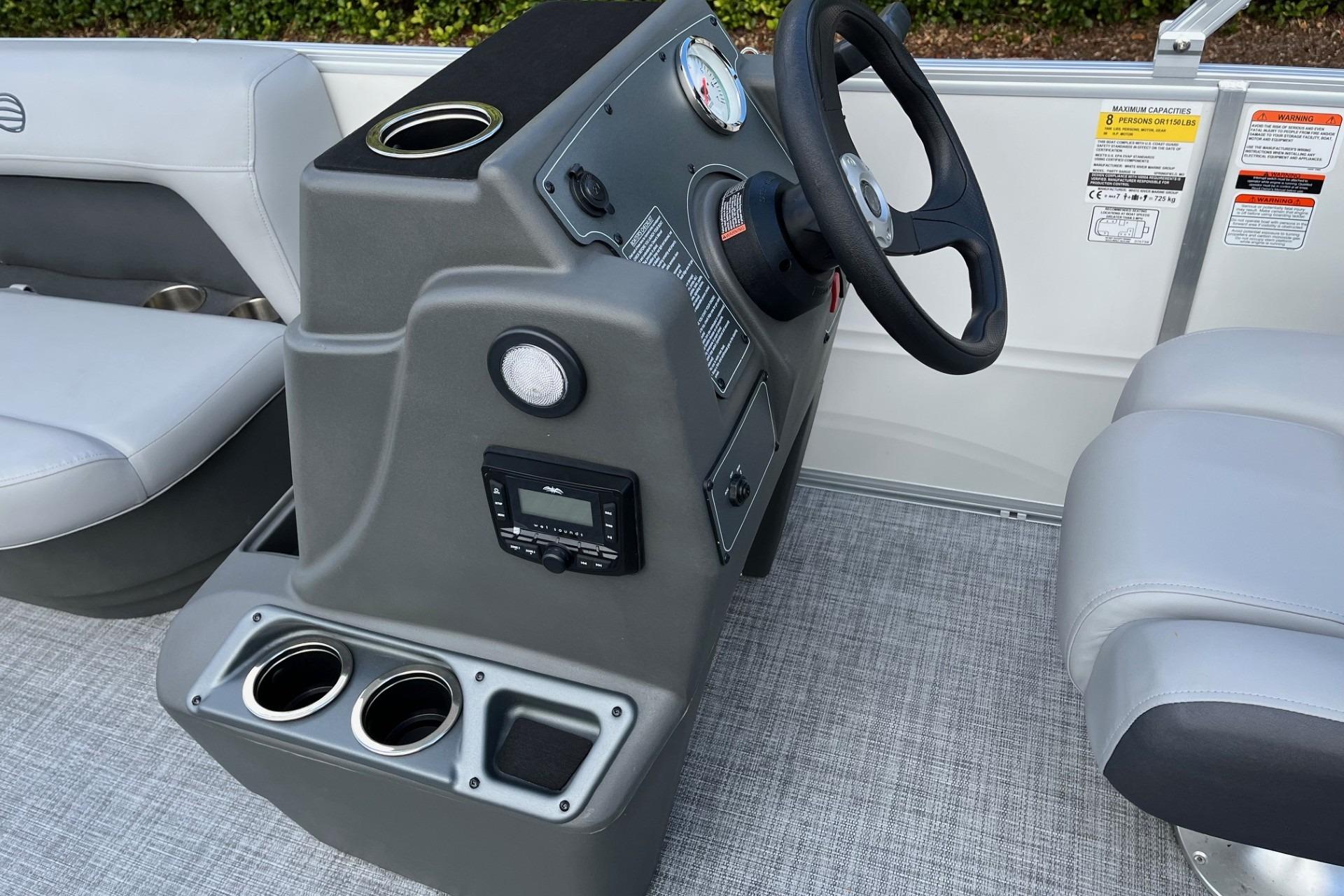 2026 Sun Tracker Party Barge 16 DLX helm with steering wheel and cup holders.