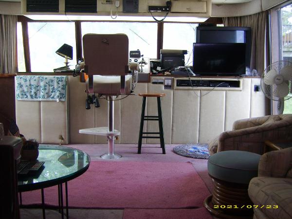 Interior of a 1980 Pluckebaum Baymaster boat with helm, electronics, and seating area.