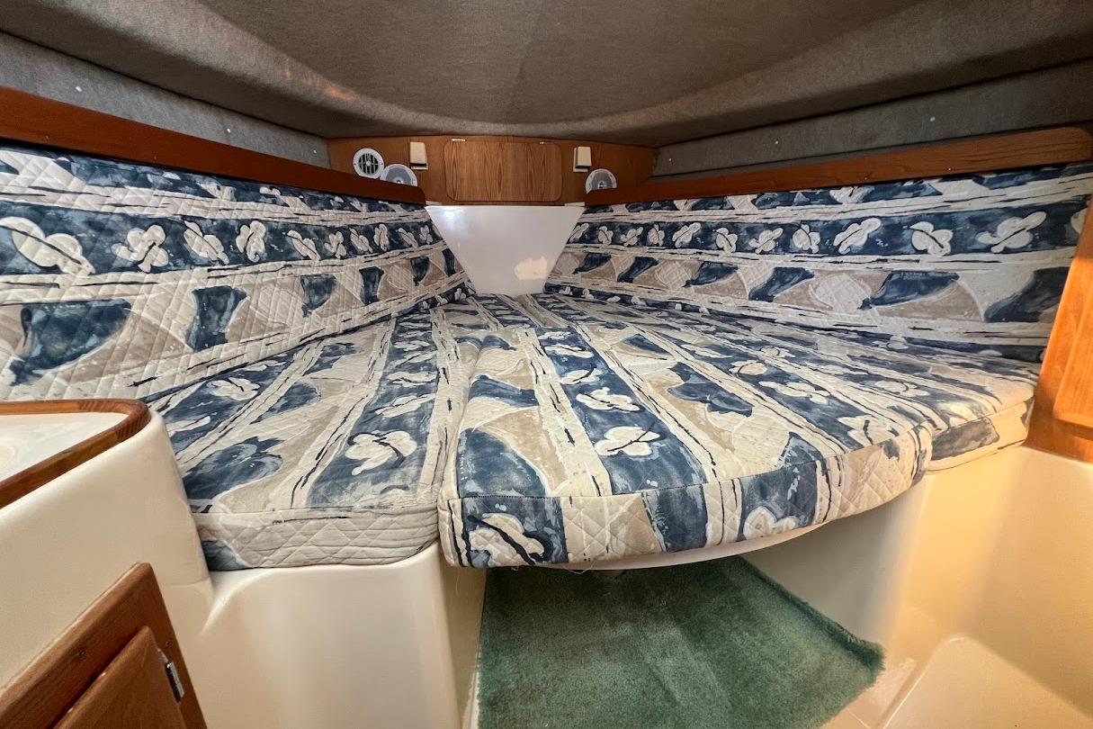 1998 Henriques 28 Express cabin with floral-patterned bedding and wood accents.