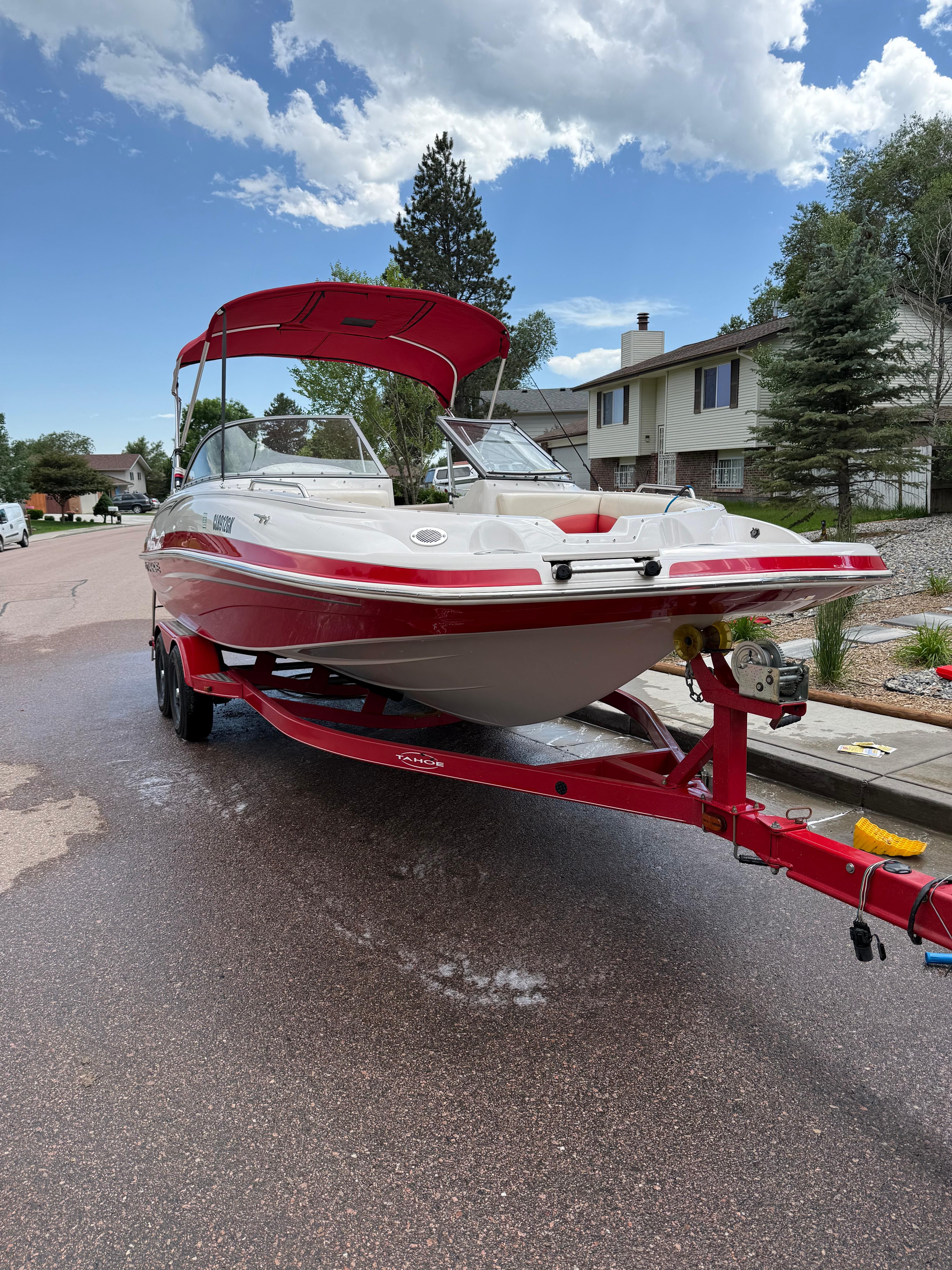 2011 Tahoe 216 WT boat on trailer in residential area.