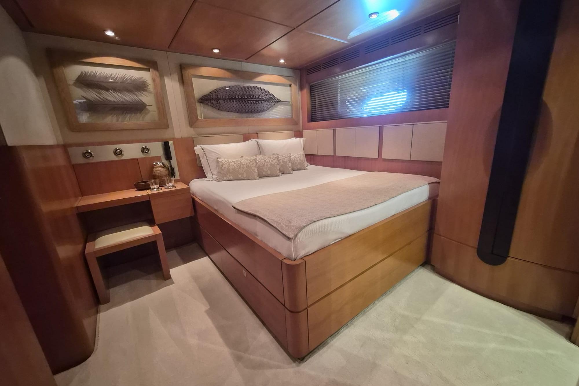 Luxurious bedroom interior on a 2004 Dereli 39m yacht, featuring elegant wood finishes.