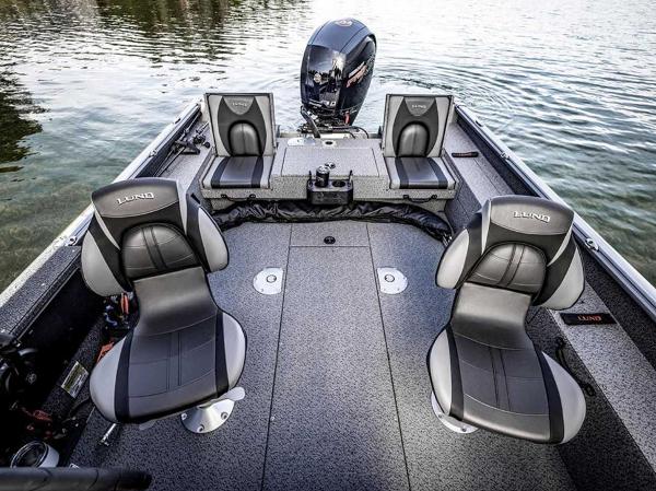 2026 Lund 1875 Impact XS boat interior with seating and motor on water.