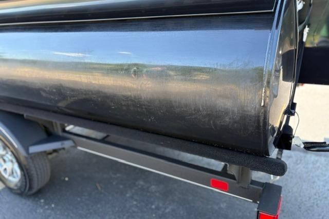 2025 Regency 250 DL3 pontoon boat on trailer, close-up view of black hull.