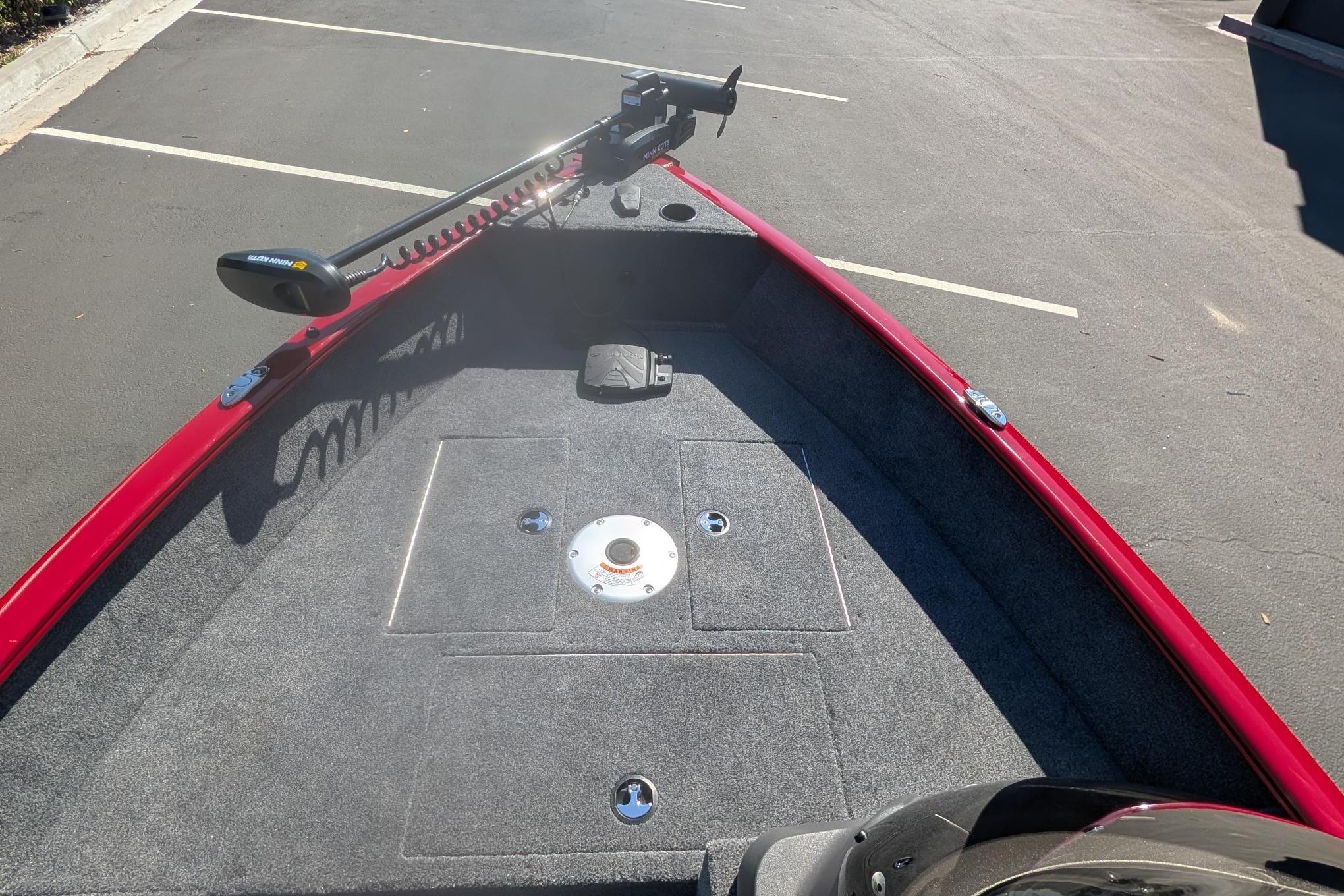2026 Tracker Super Guide V-16 SC boat interior with trolling motor in parking lot.