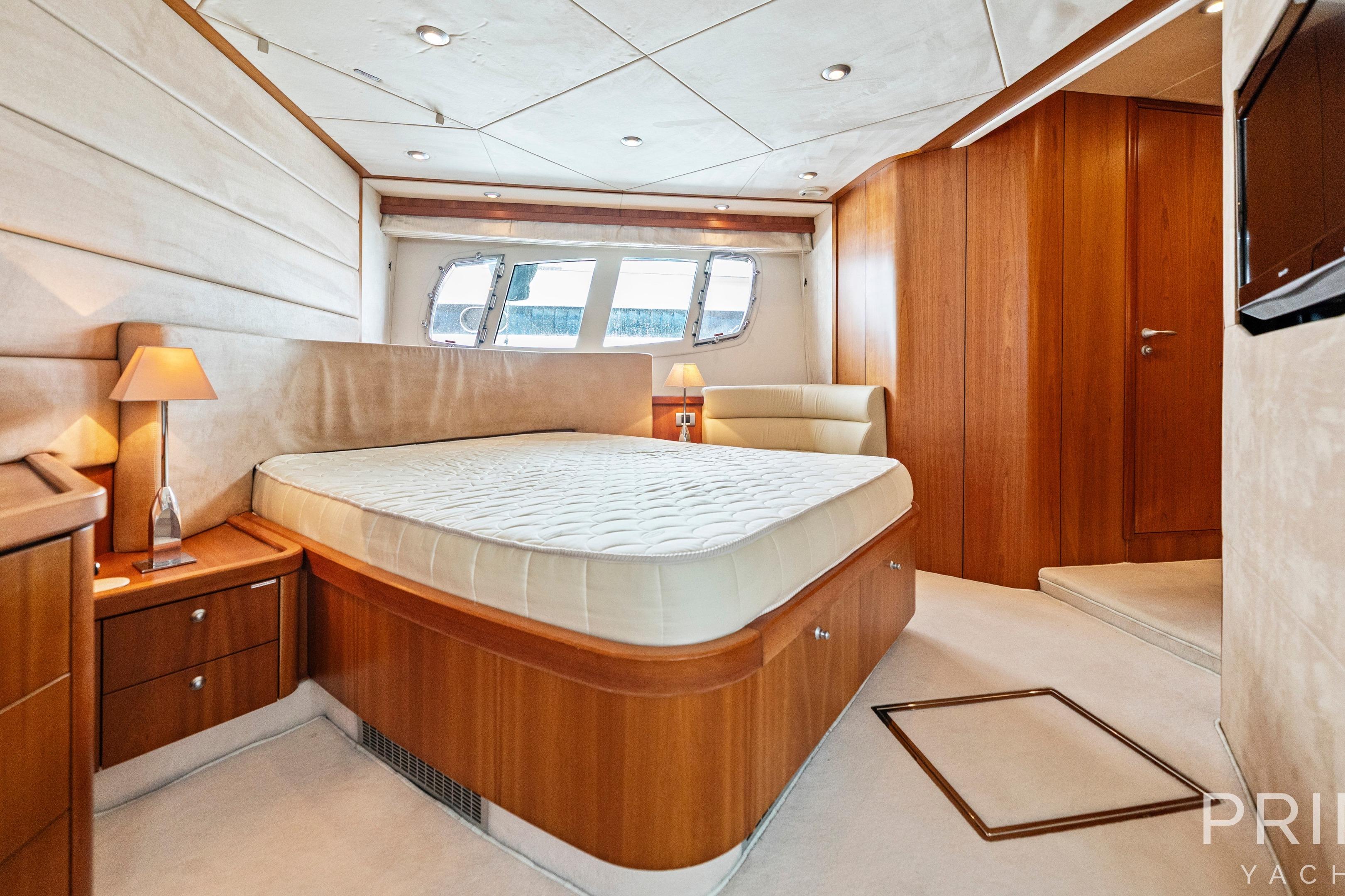 Luxurious bedroom interior of 2008 Sunseeker Manhattan 70 yacht with elegant wood finishes.