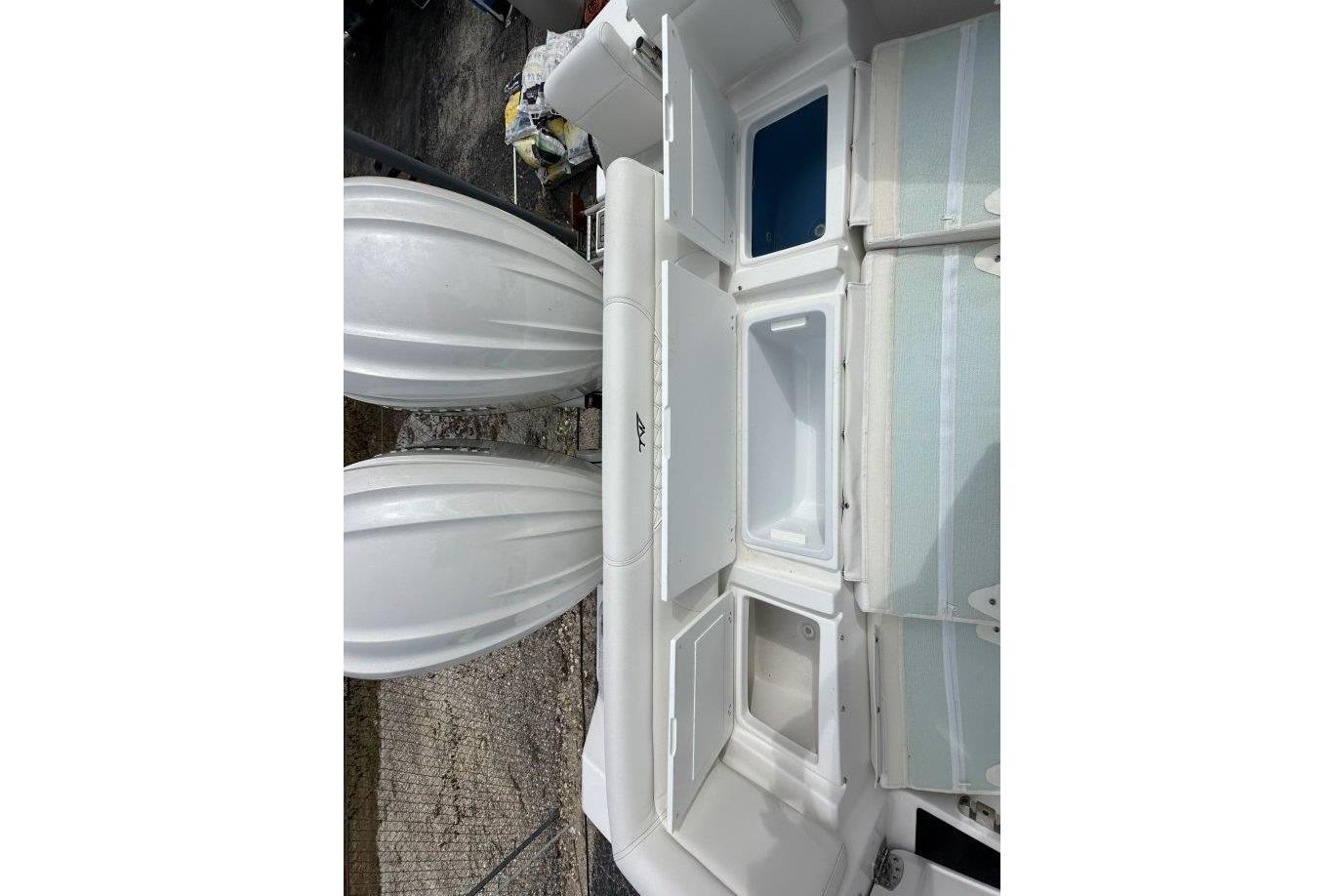 2026 Tidewater 272 LXF boat interior with storage compartments and twin engines.