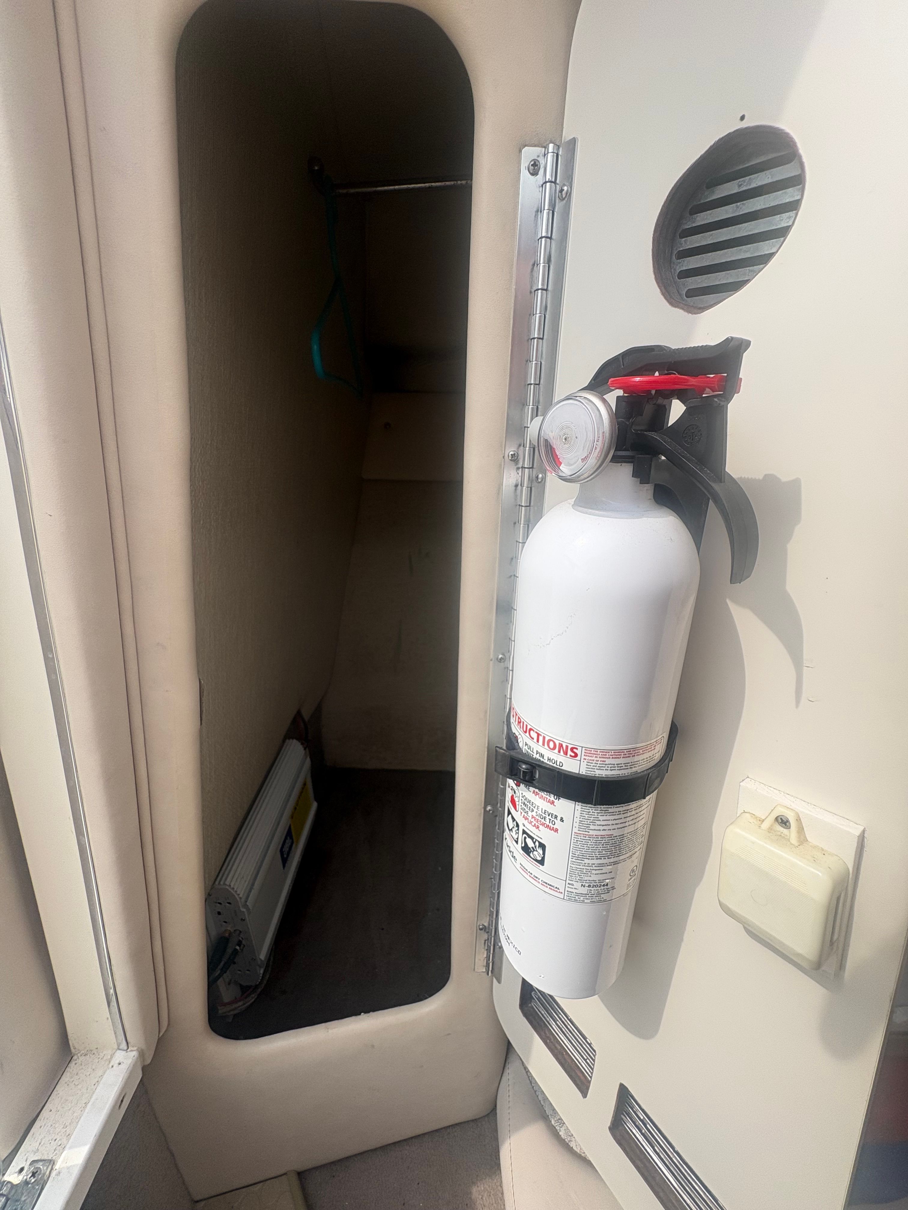 Interior of a 1996 Sea Ray 280 Cuddy Cabin with a fire extinguisher mounted on the wall.