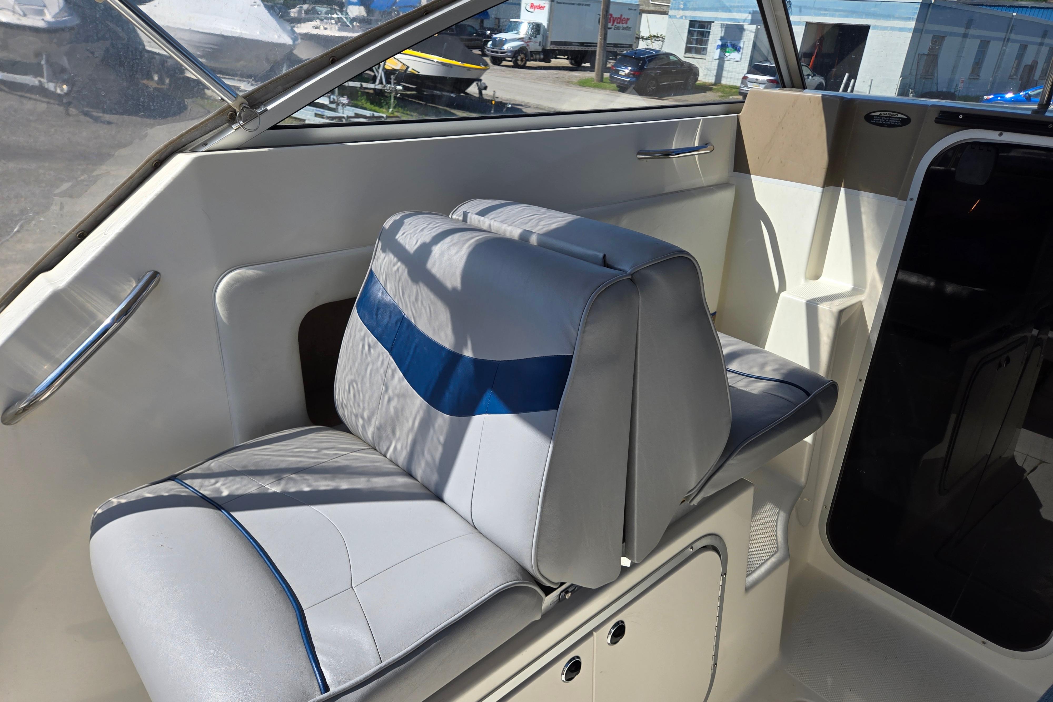 Interior seating of a 2006 Bayliner 222 Classic boat, featuring blue and white upholstery.