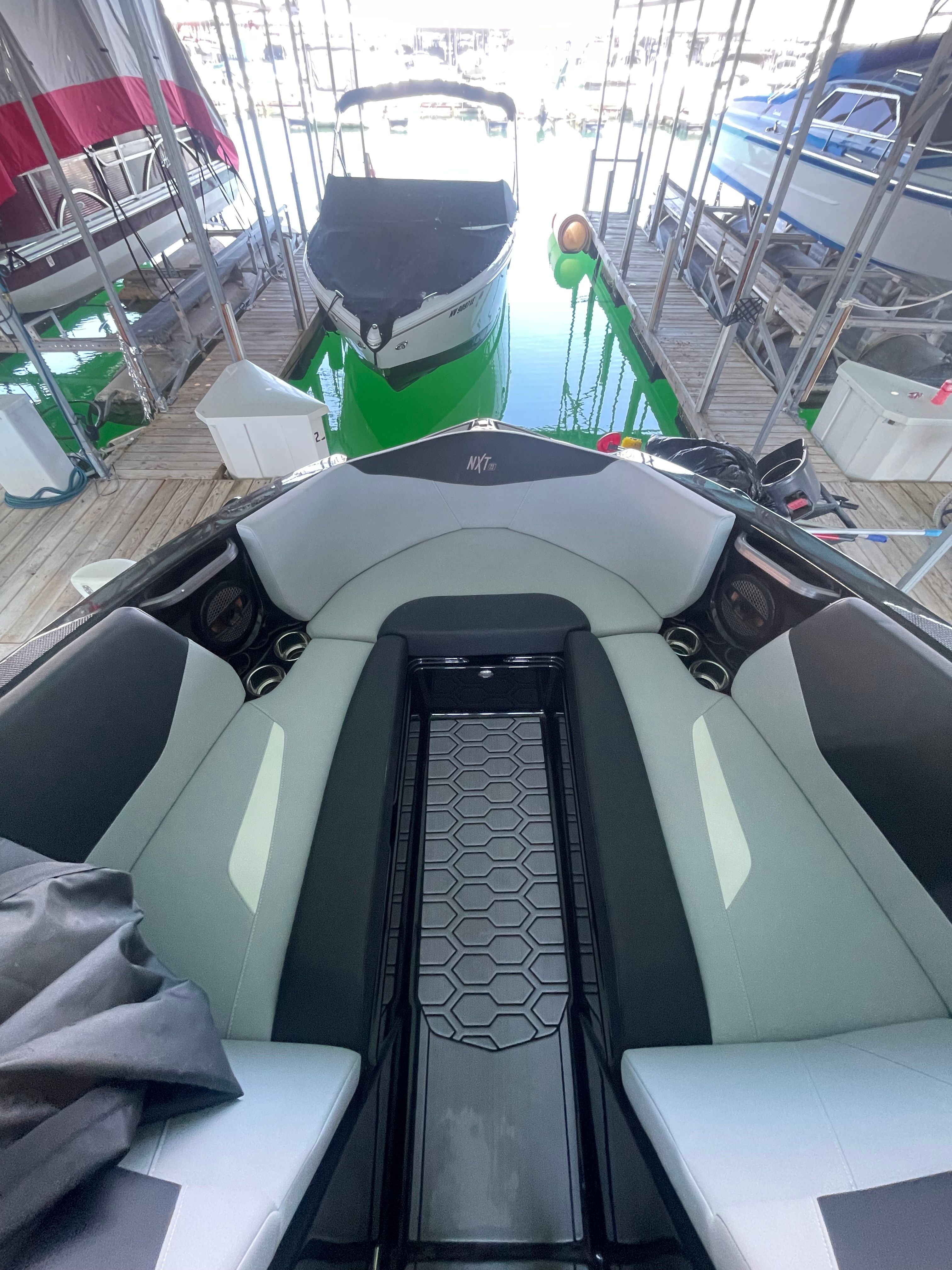 A modern boat with a stylish interior is docked in a covered marina.
