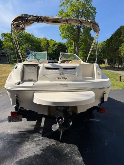 A 2001 Sea Ray 210 Sundeck on a trailer. It features a sunshade and swim platform.