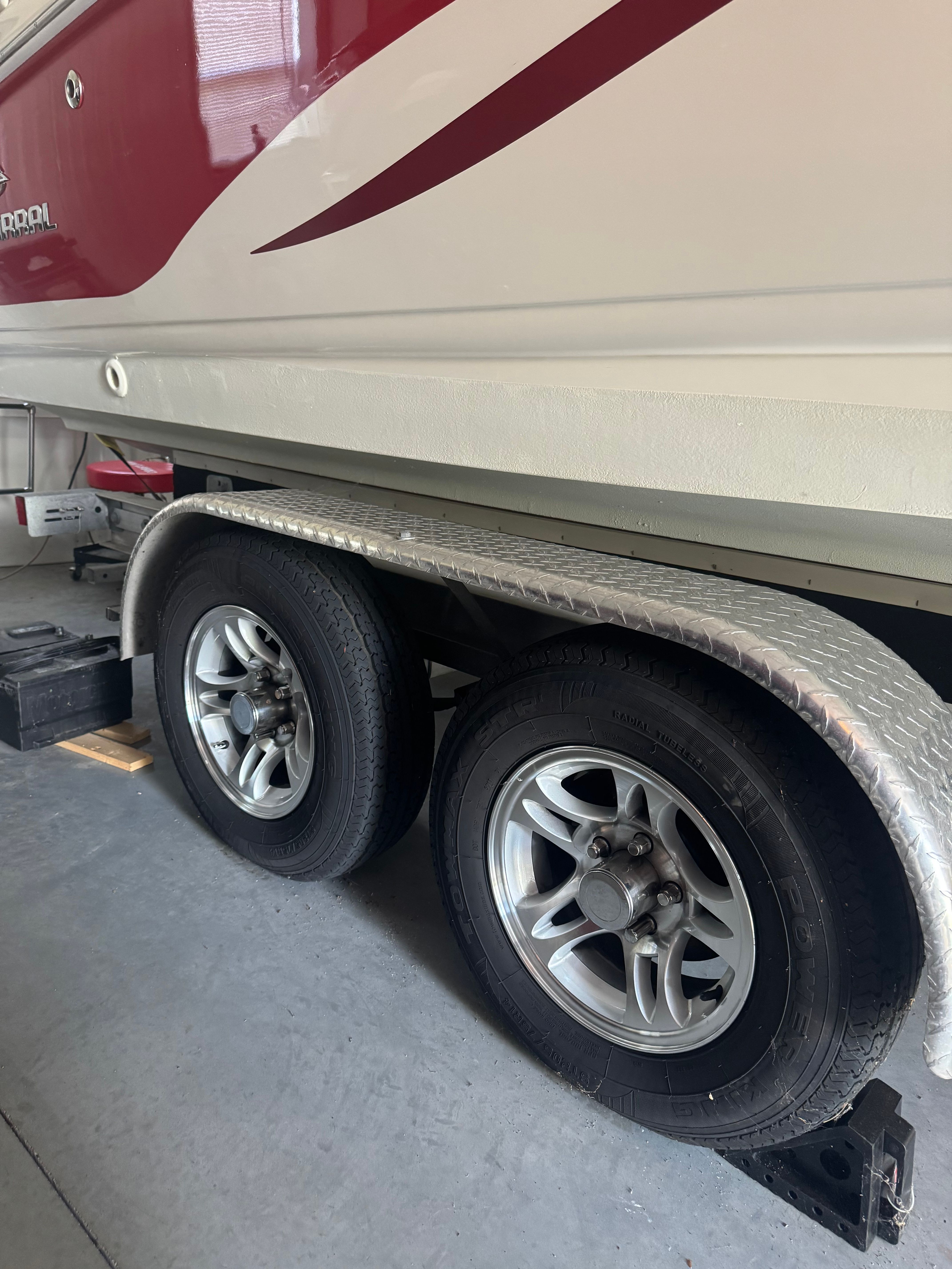 A 2006 Chaparral 235 SSi boat on a trailer with two wheels in a garage.