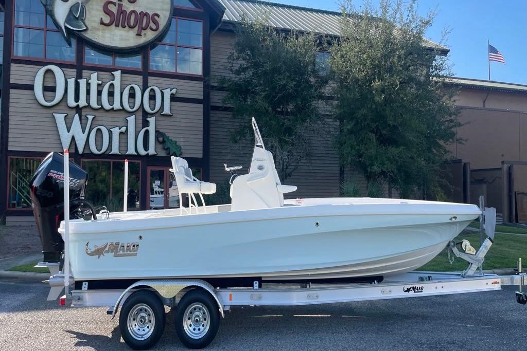 2026 Mako 24 APEX boat on trailer outside Outdoor World store.