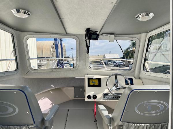Interior of 2023 Defiance Admiral 220 EX boat with steering wheel and navigation system.