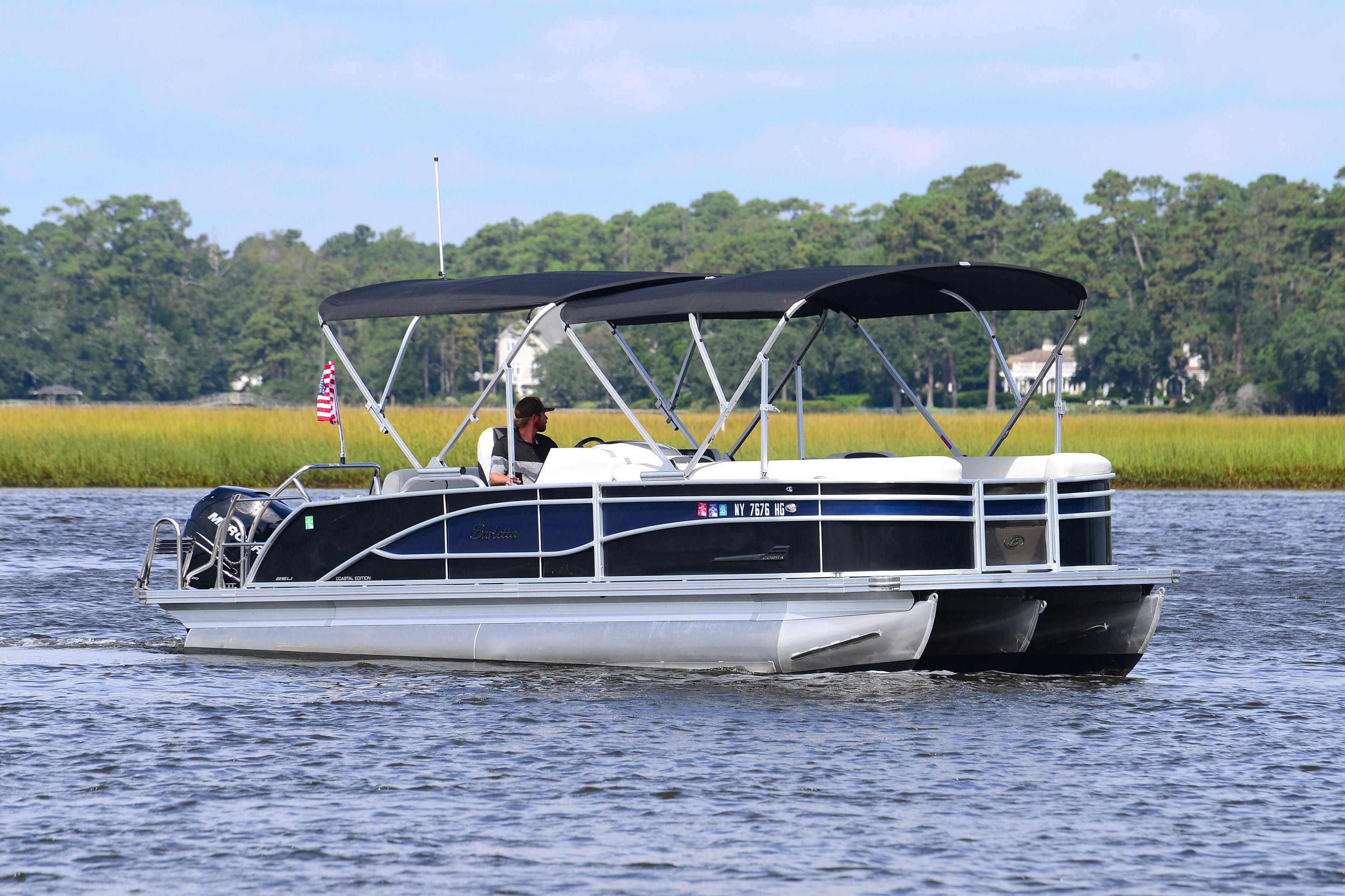 2022 Barletta Corsa 25U pontoon boat cruising on a scenic lake.