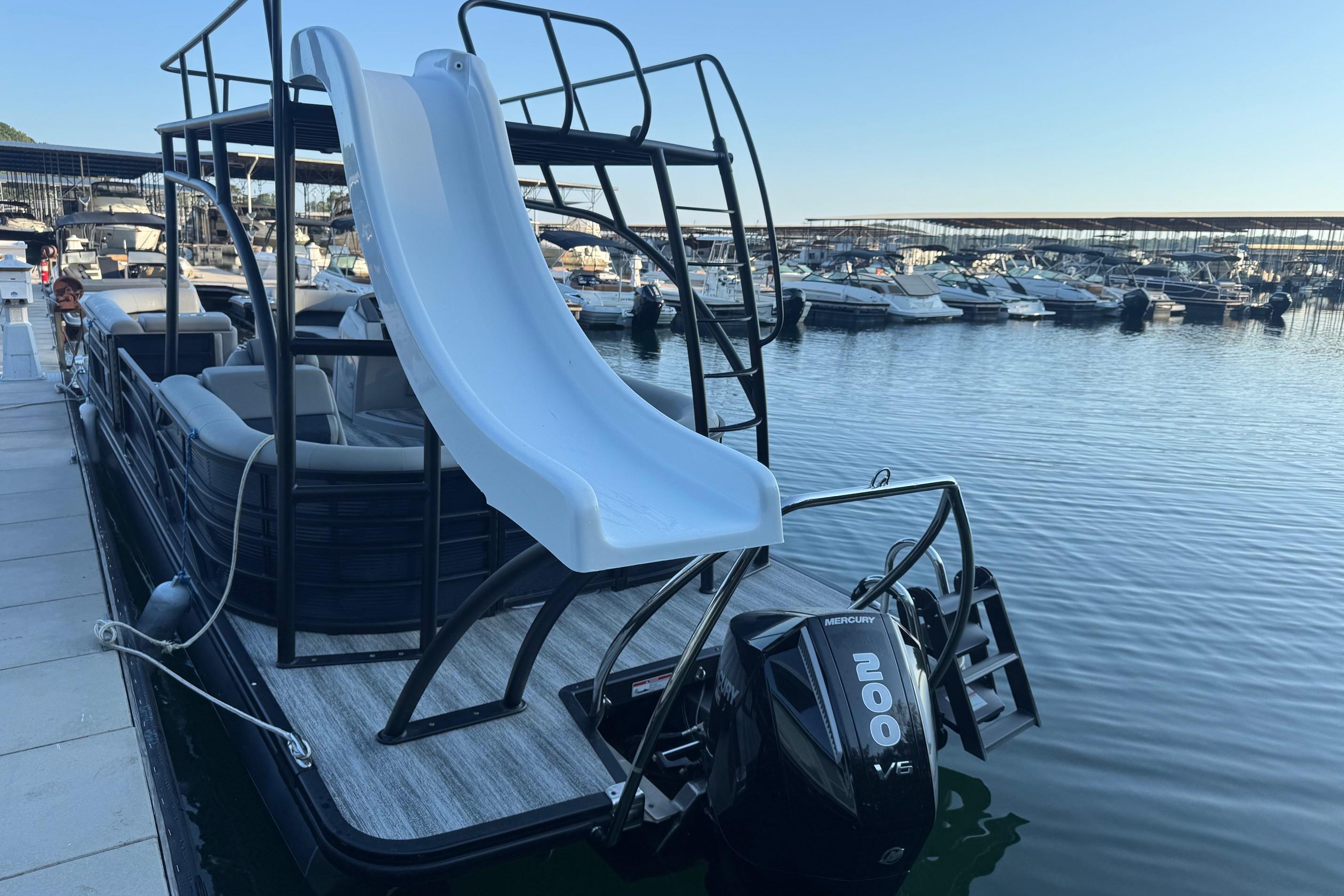 2025 Bennington 26 L Top Deck pontoon boat with slide, docked at marina.