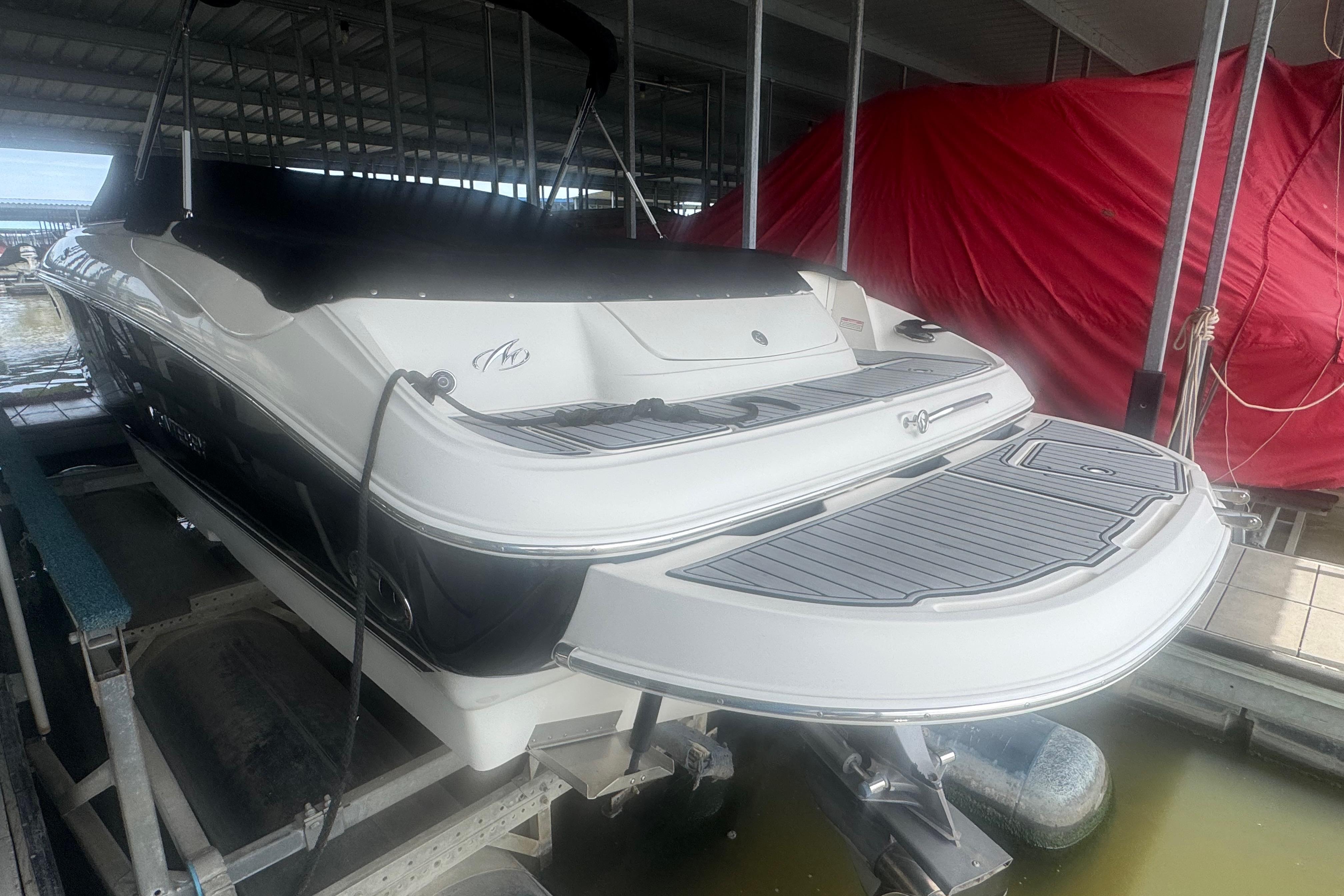 2005 Monterey 248LS Montura Bowrider in dock, rear view, covered storage.