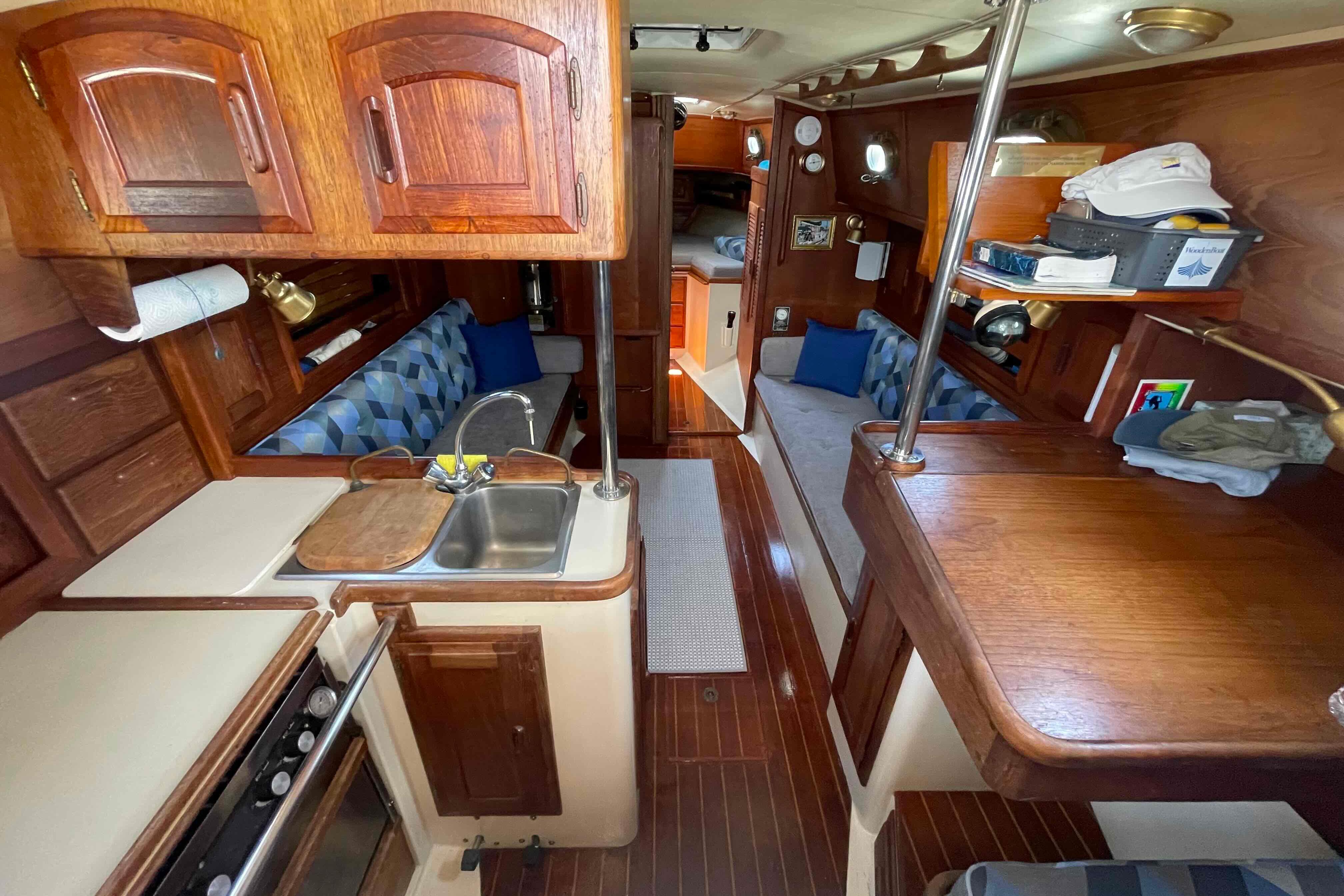 Interior of a 1987 Pacific Seacraft 34 sailboat with wood finishes and cozy seating.