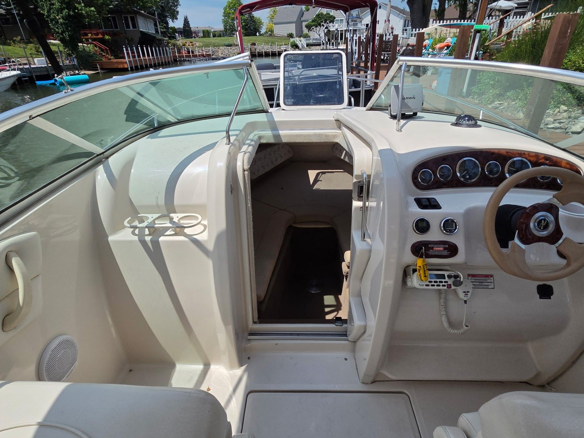 The image shows the cockpit of a 2002 Sea Ray 225 Weekender. It features a sleek dashboard and open cabin.