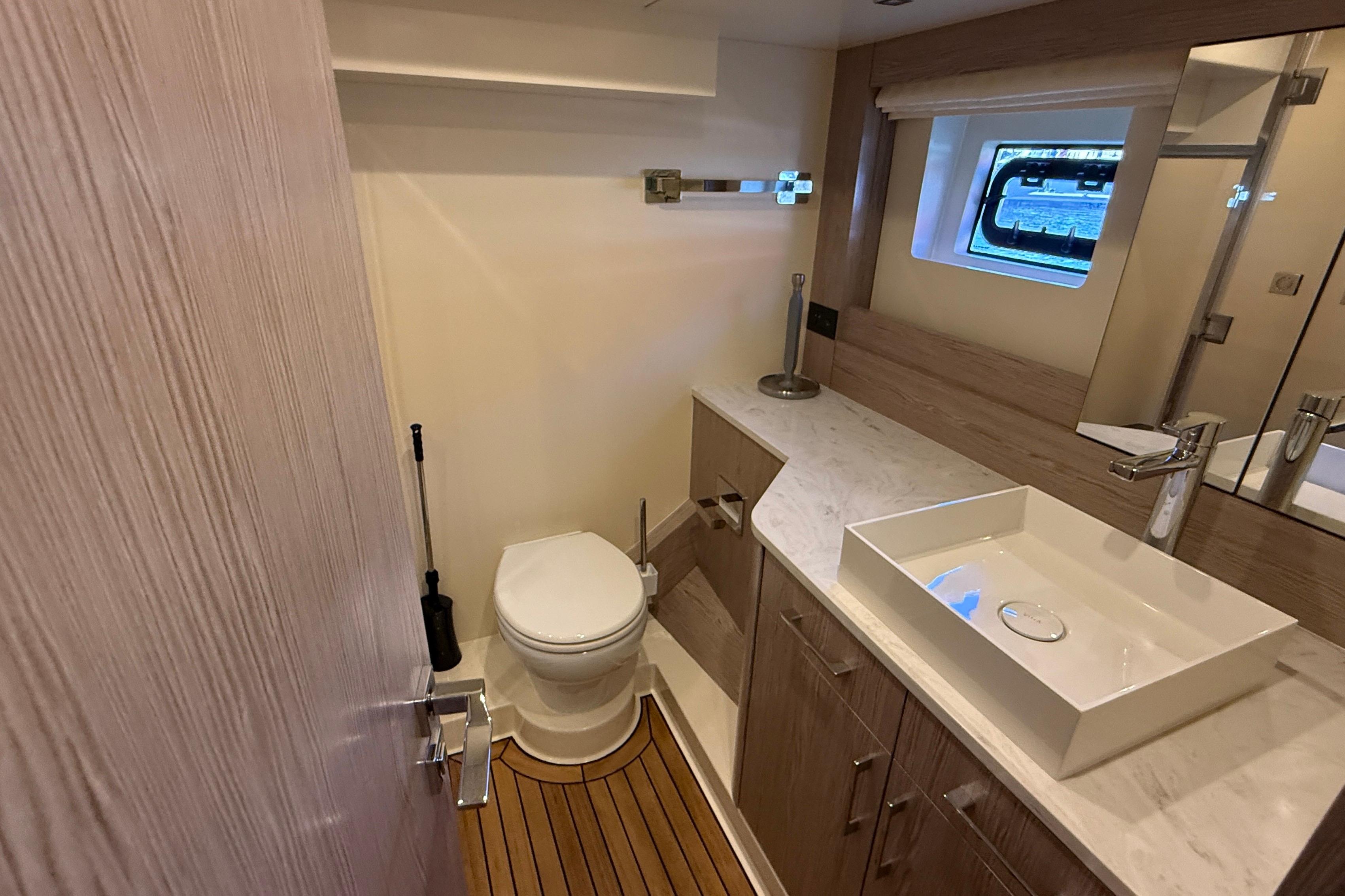 Modern bathroom in 2022 Sirena 58 yacht with sleek fixtures and wooden accents.