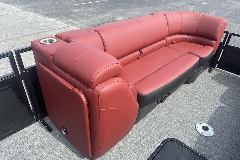 Luxurious red seating on 2026 Regency 230 DL pontoon boat, featuring cup holder.