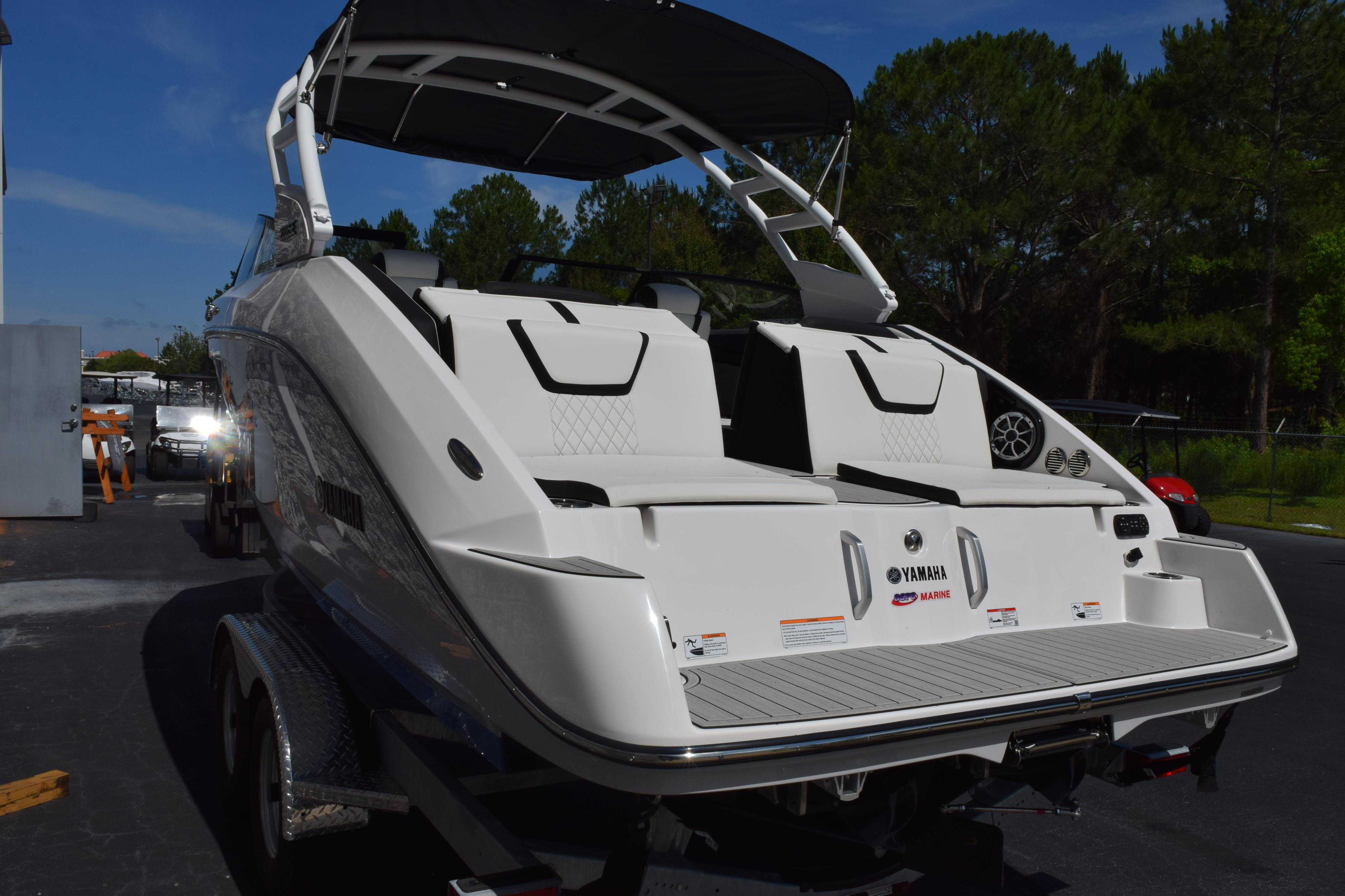 2026 Yamaha Boats 222SE, sleek white design, parked on trailer, outdoor setting.
