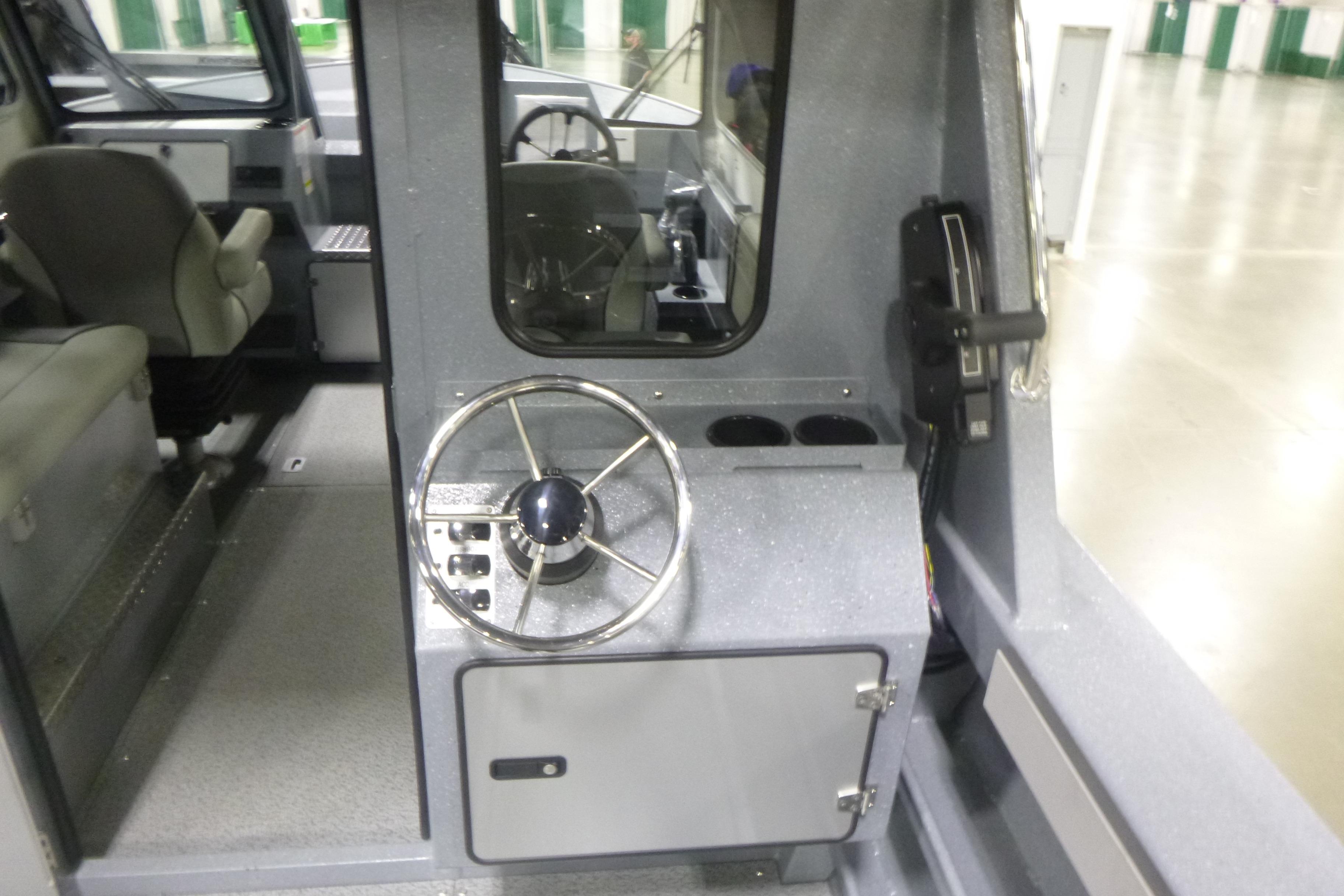 Interior view of 2026 KingFisher 2425 Escape HT boat, featuring steering wheel and seating.