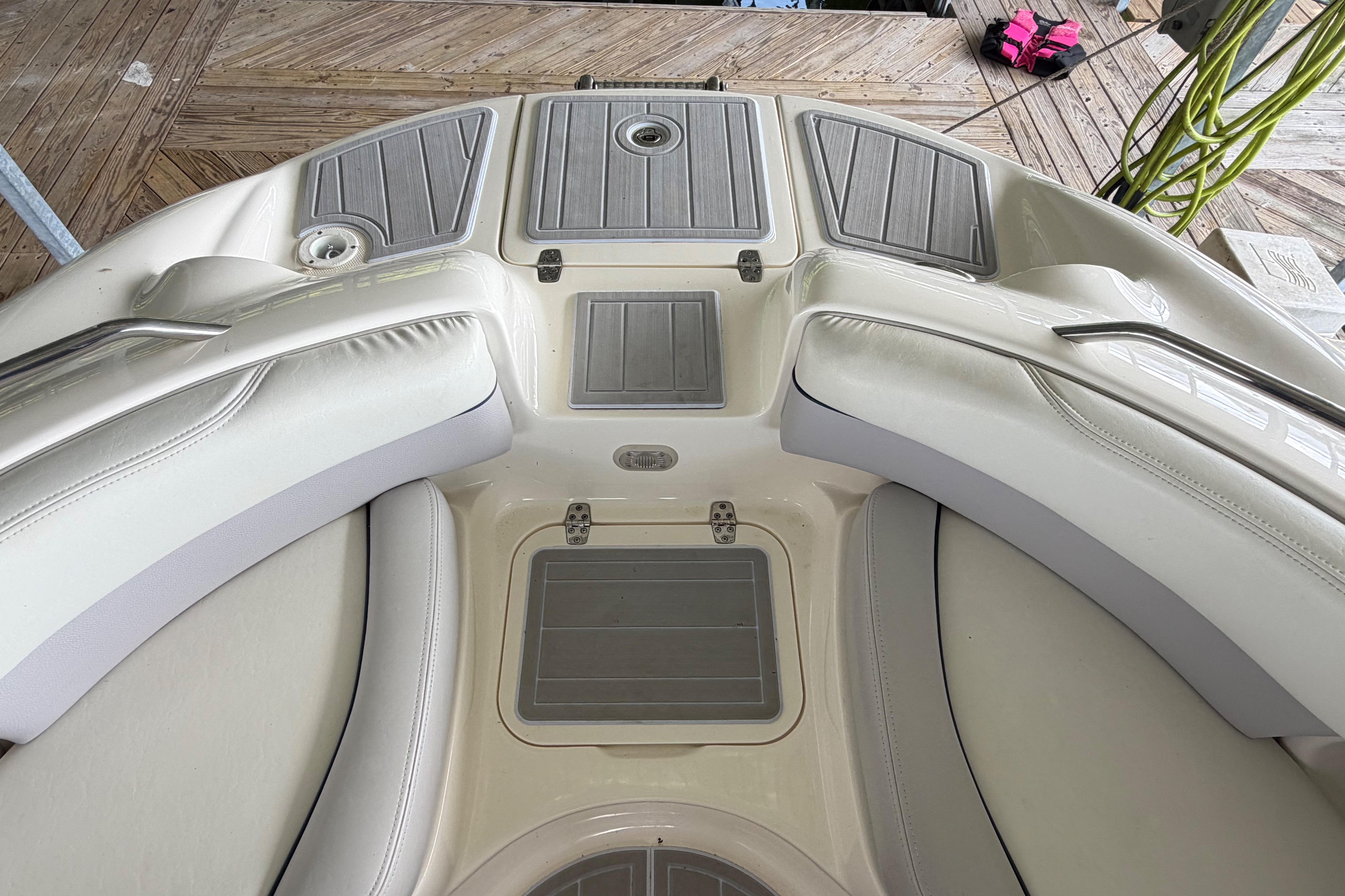 Interior view of a 2010 Bryant 255 boat with cushioned seating and deck storage.