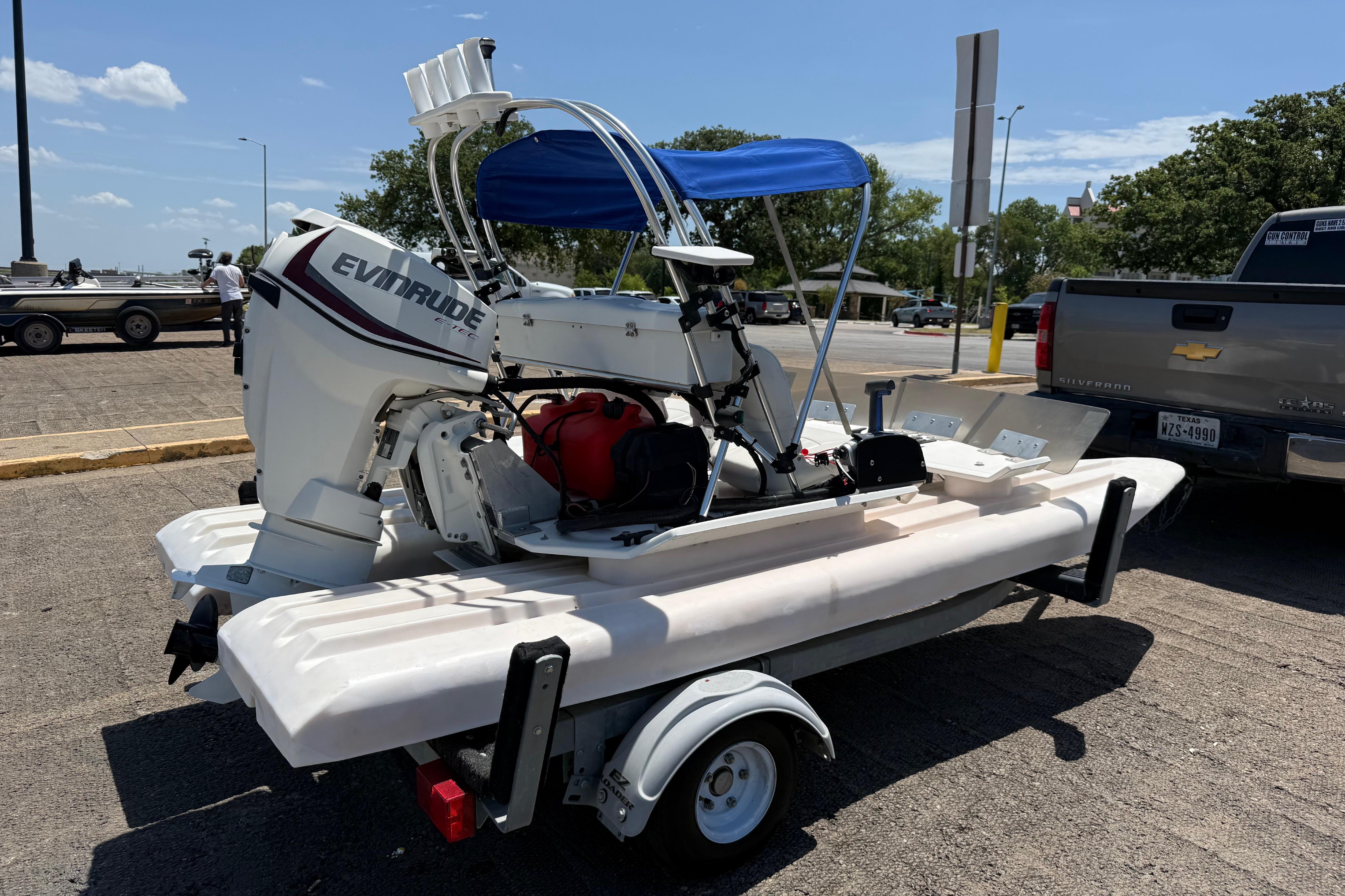 2016 CraigCat E2 Elite with Evinrude motor on trailer, parked in sunny lot.
