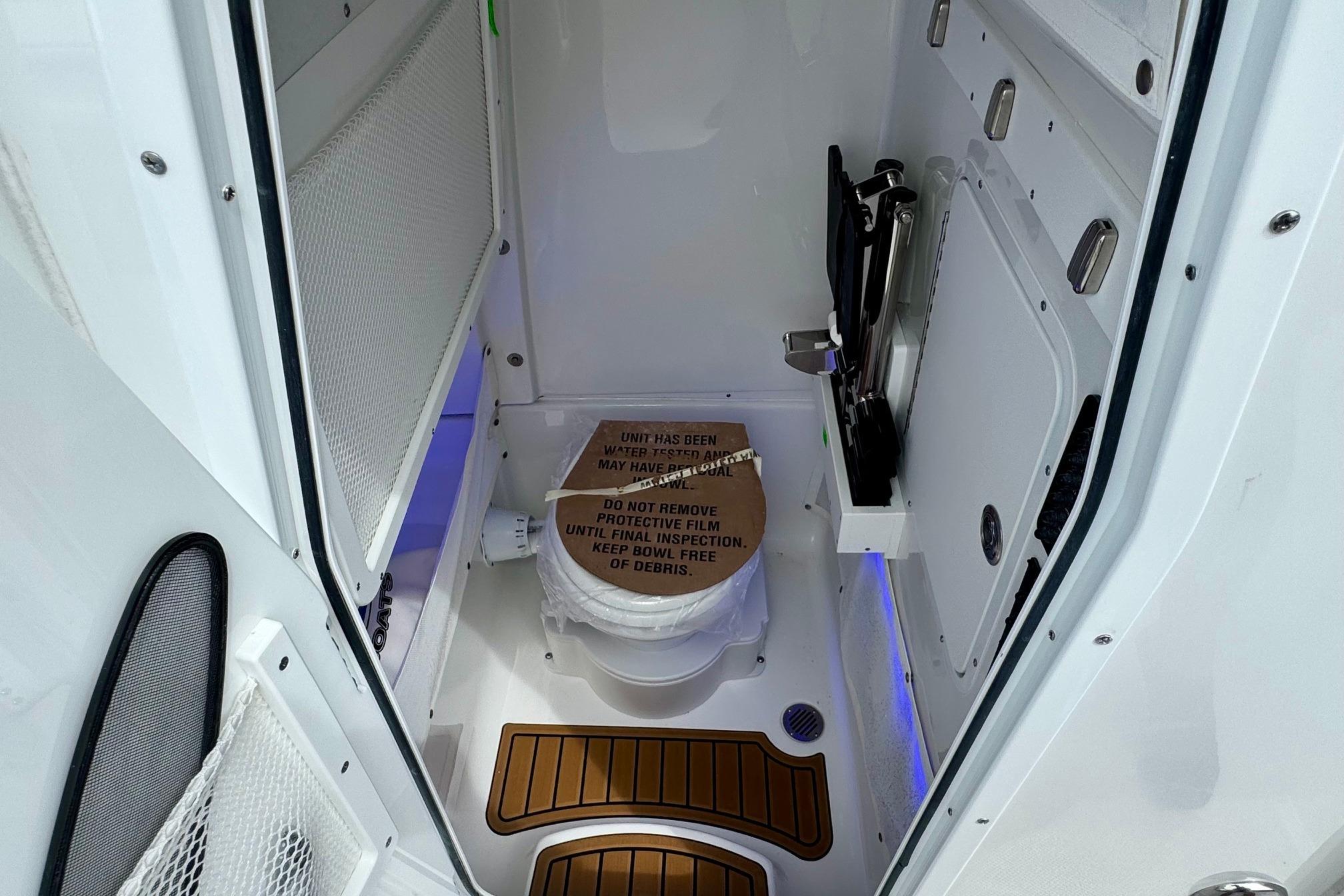 2026 Sea Hunt Ultra 275 SE boat interior with compact bathroom and modern fixtures.