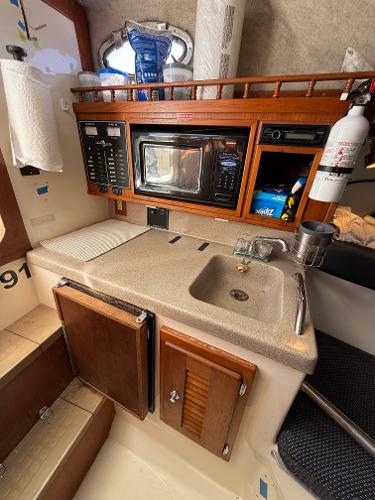 2001 Albemarle 280 Express Sport Fisherman galley with sink, microwave, and storage cabinets.