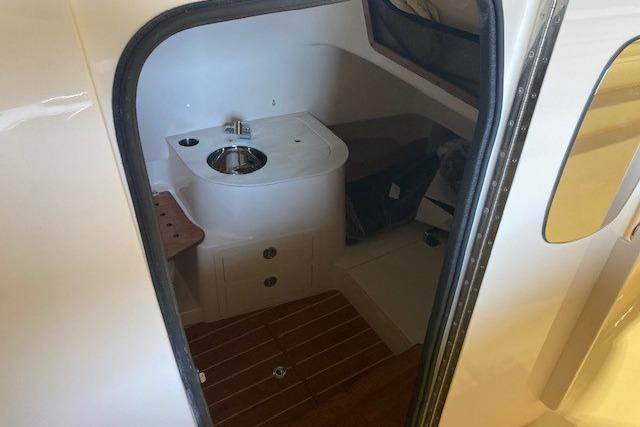 Interior of 2026 Grady-White Canyon 336 boat, featuring compact sink and wooden flooring.