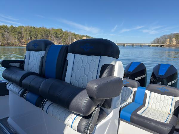 2024 Fountain 34 SC boat seats with blue accents on a calm lake.