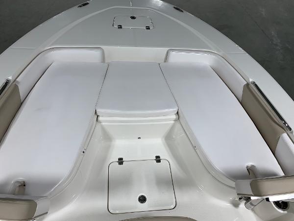 2026 Robalo 226 Cayman boat interior with white cushioned seating and storage compartments.