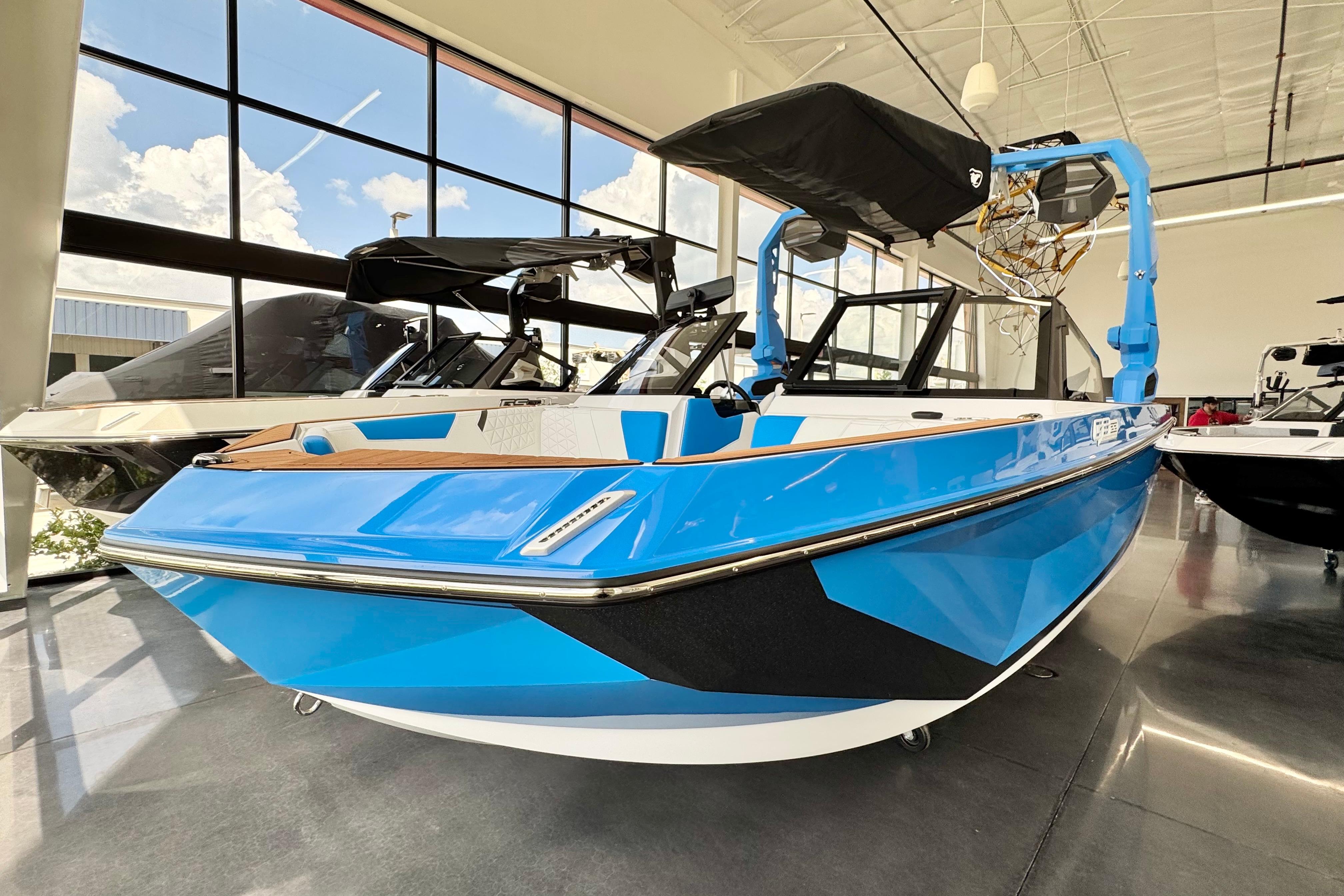 2026 Nautique Super Air Nautique GS22 in showroom, vibrant blue exterior, modern design.