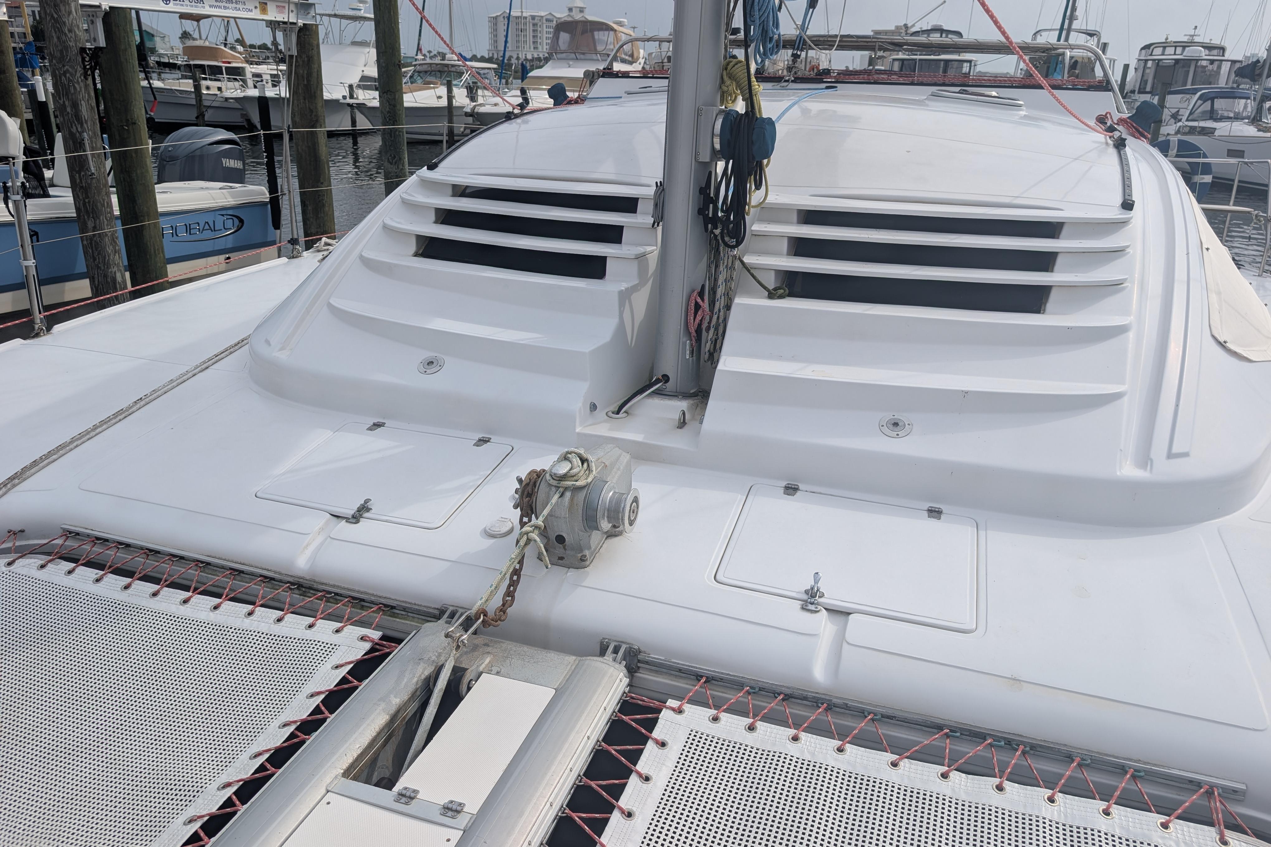 1999 Island Spirit 37 catamaran deck with winch and netting in marina setting.