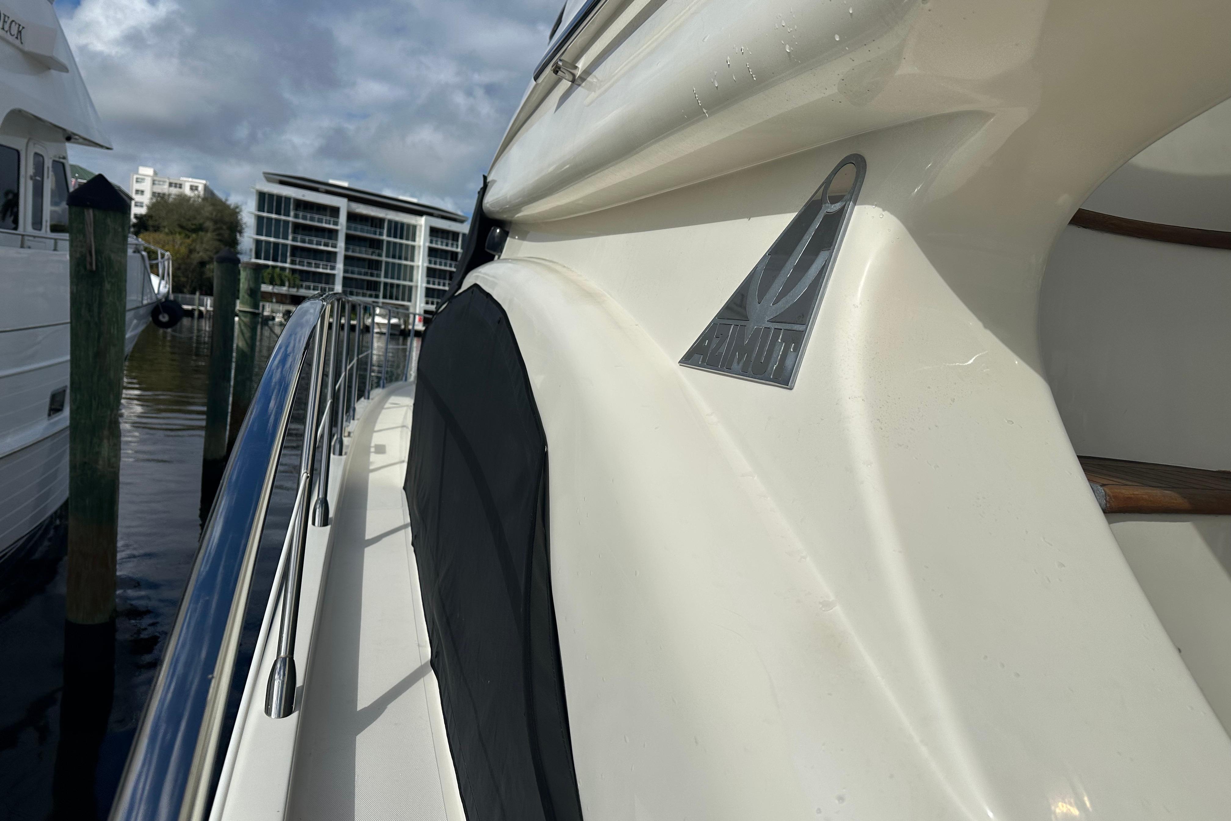 Side view of a 2004 Azimut 55E yacht docked at a marina.
