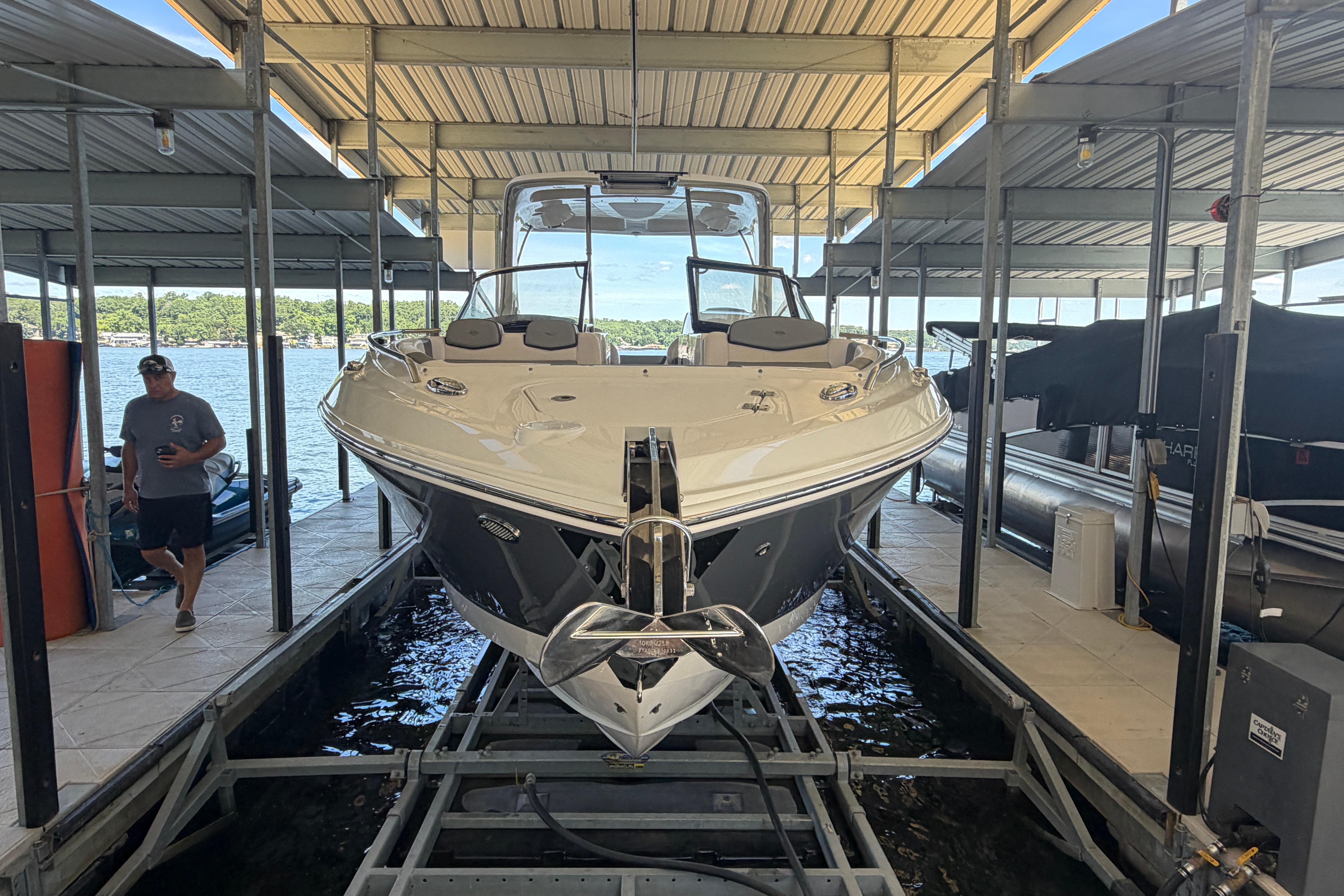 2018 Chaparral 347 SSX boat docked under a covered marina with a person nearby.