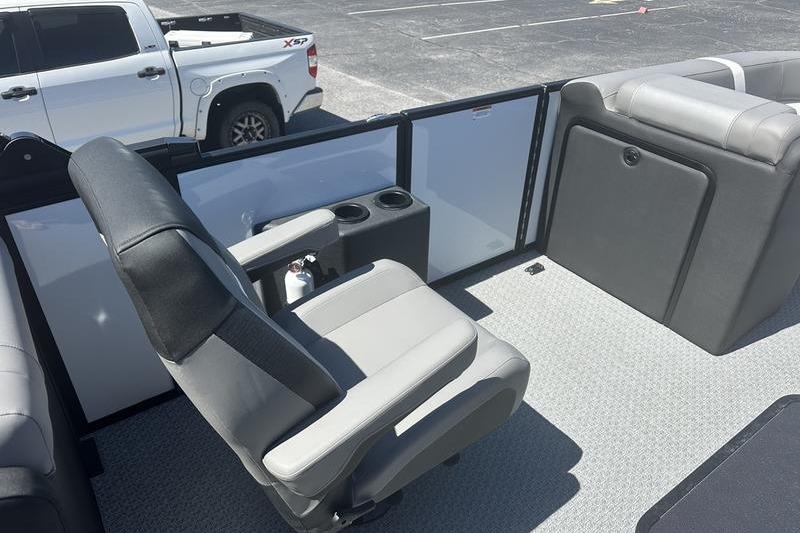 Interior of 2026 Evotti 523QL boat with seating and cup holders, parked truck visible.