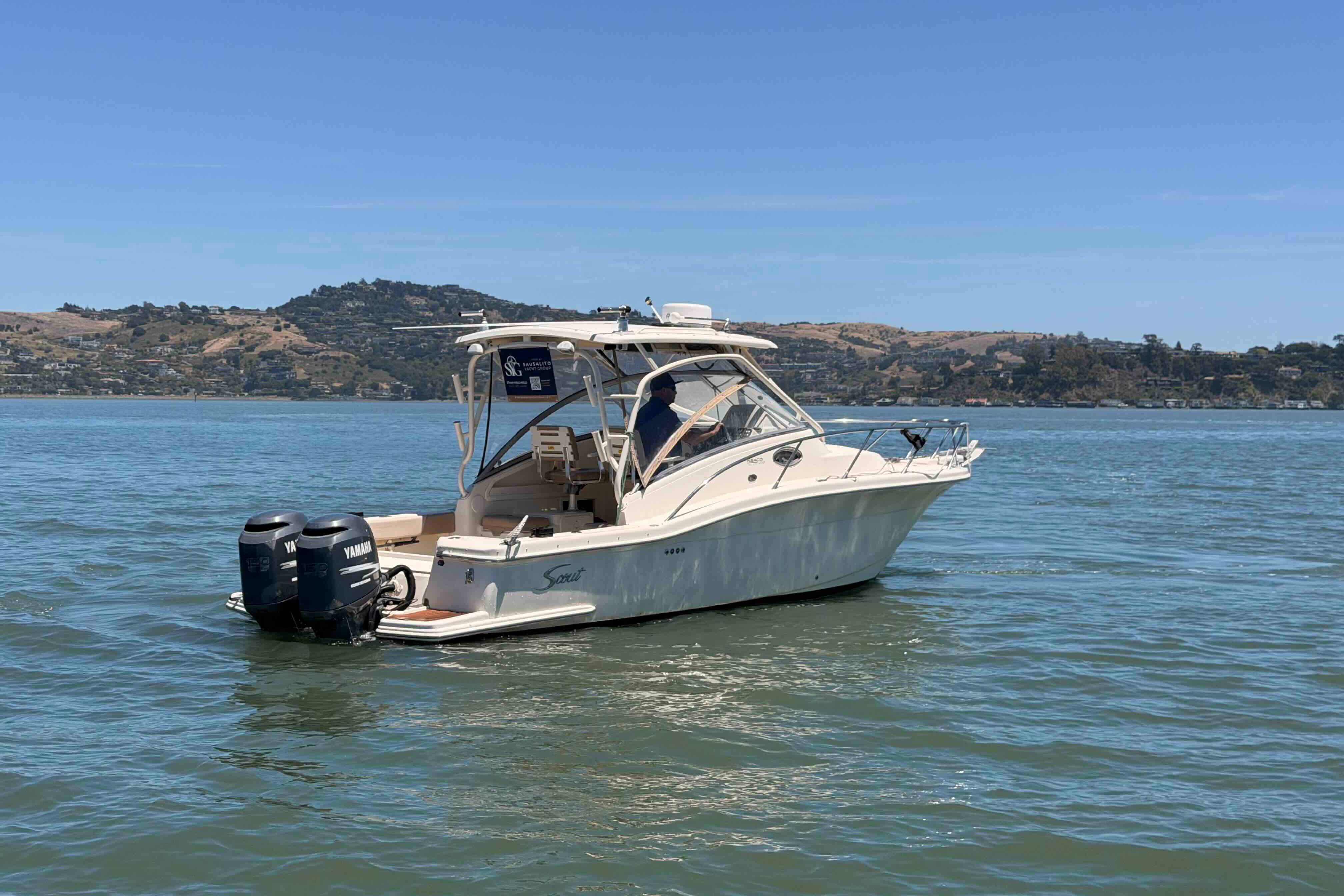 2007 Scout 262 Abaco boat on calm water with scenic hillside background.