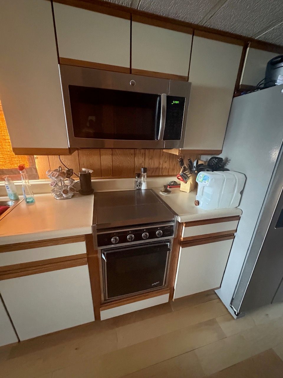 Kitchen in a houseboat with a stove, microwave, and refrigerator.