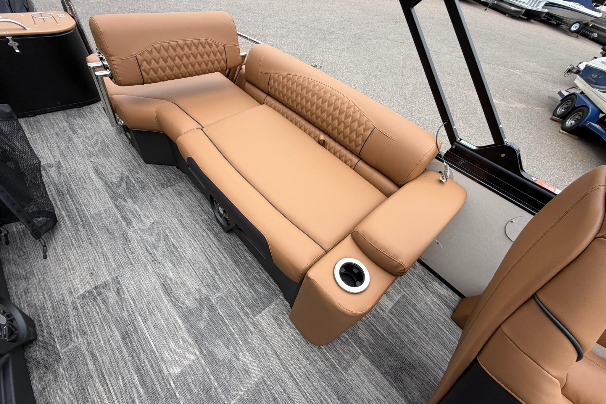 Luxurious seating on 2026 Avalon Catalina Quad Lounge Shift boat, featuring tan upholstery and cup holder.