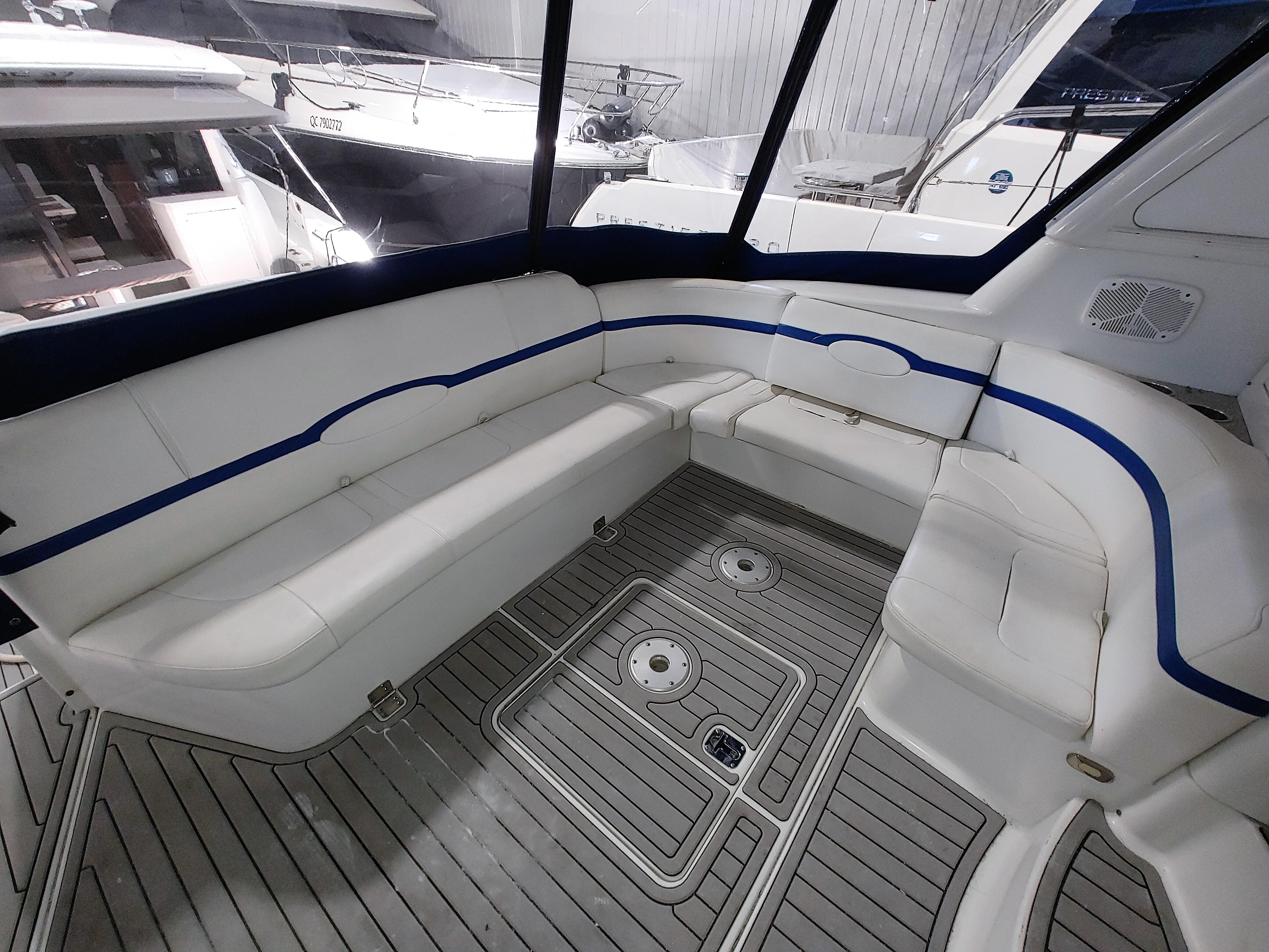 2004 Formula 47 Yacht interior with white and blue seating, spacious deck area.