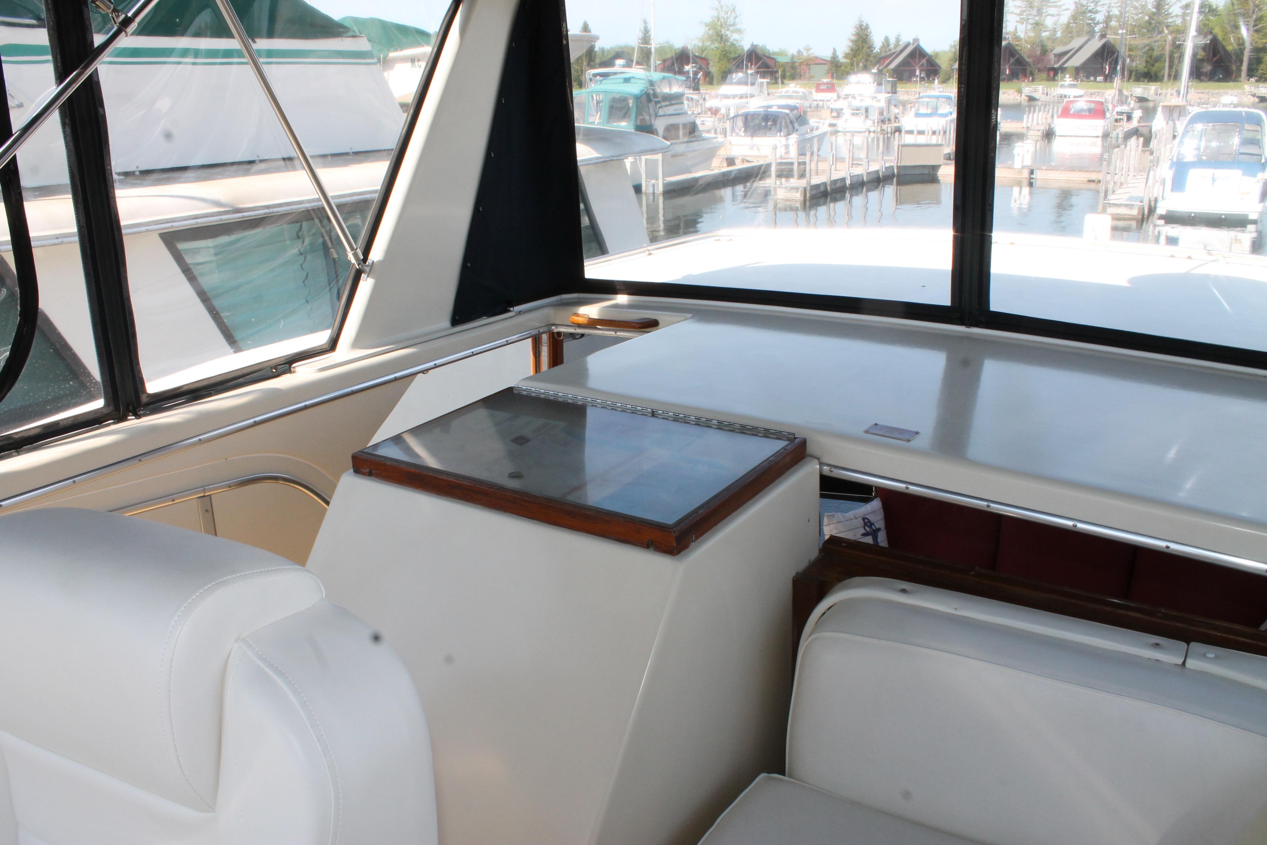Interior view of 1987 Chris-Craft 427 Catalina yacht with white seating and marina backdrop.
