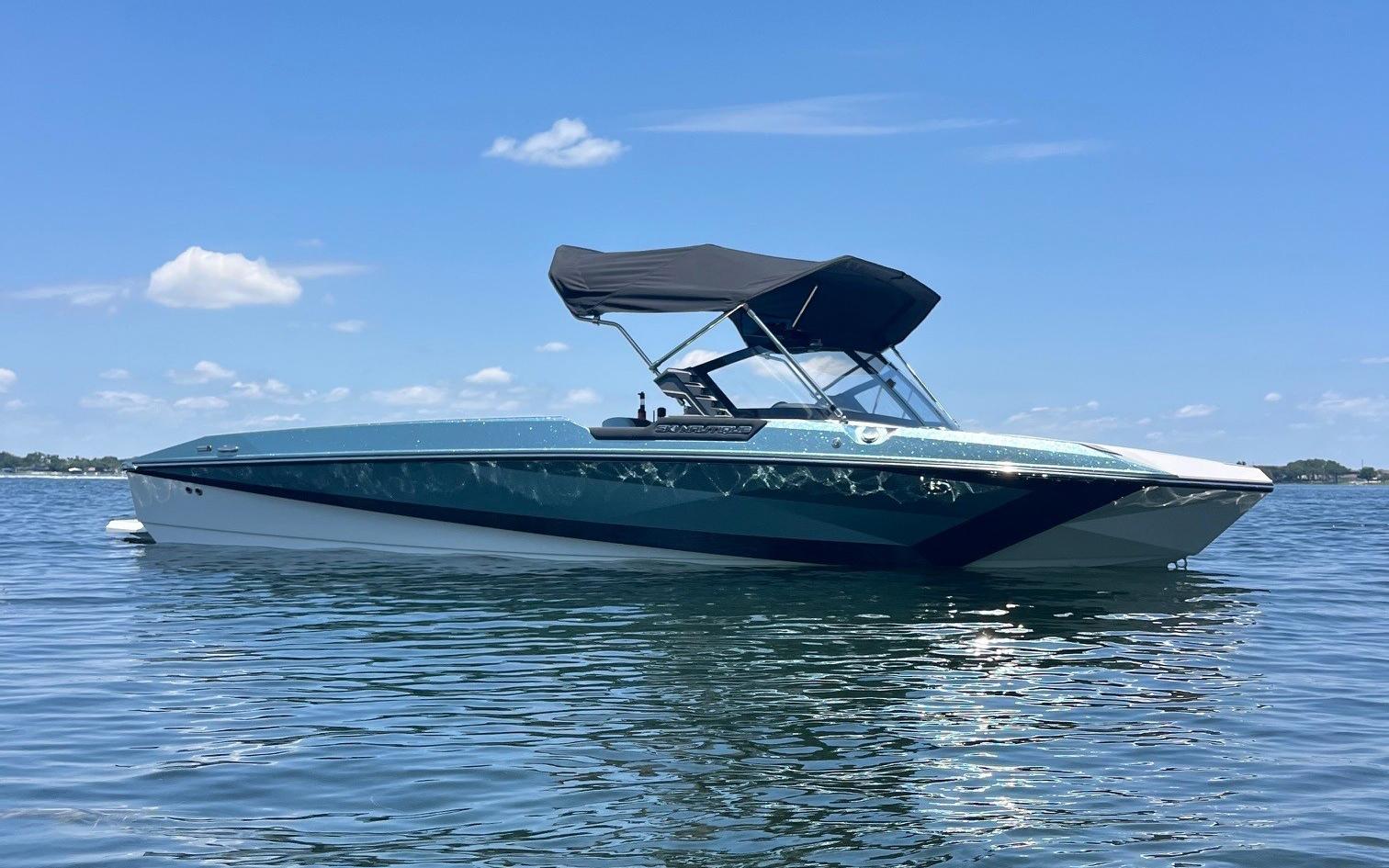 2025 Nautique Ski boat on calm water under a clear blue sky.